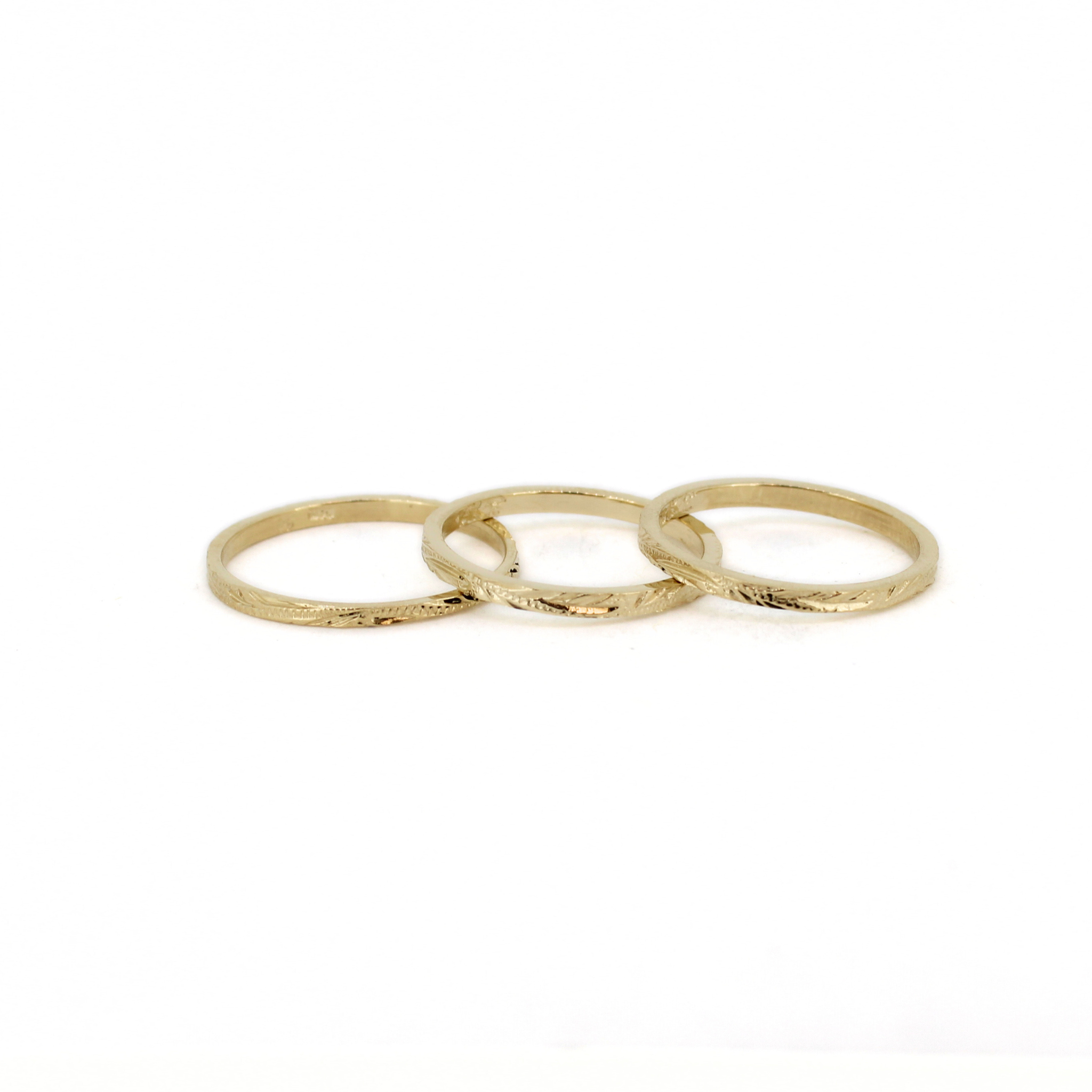 14k gold engraved rings stacked on a white background by Brianne & Co.