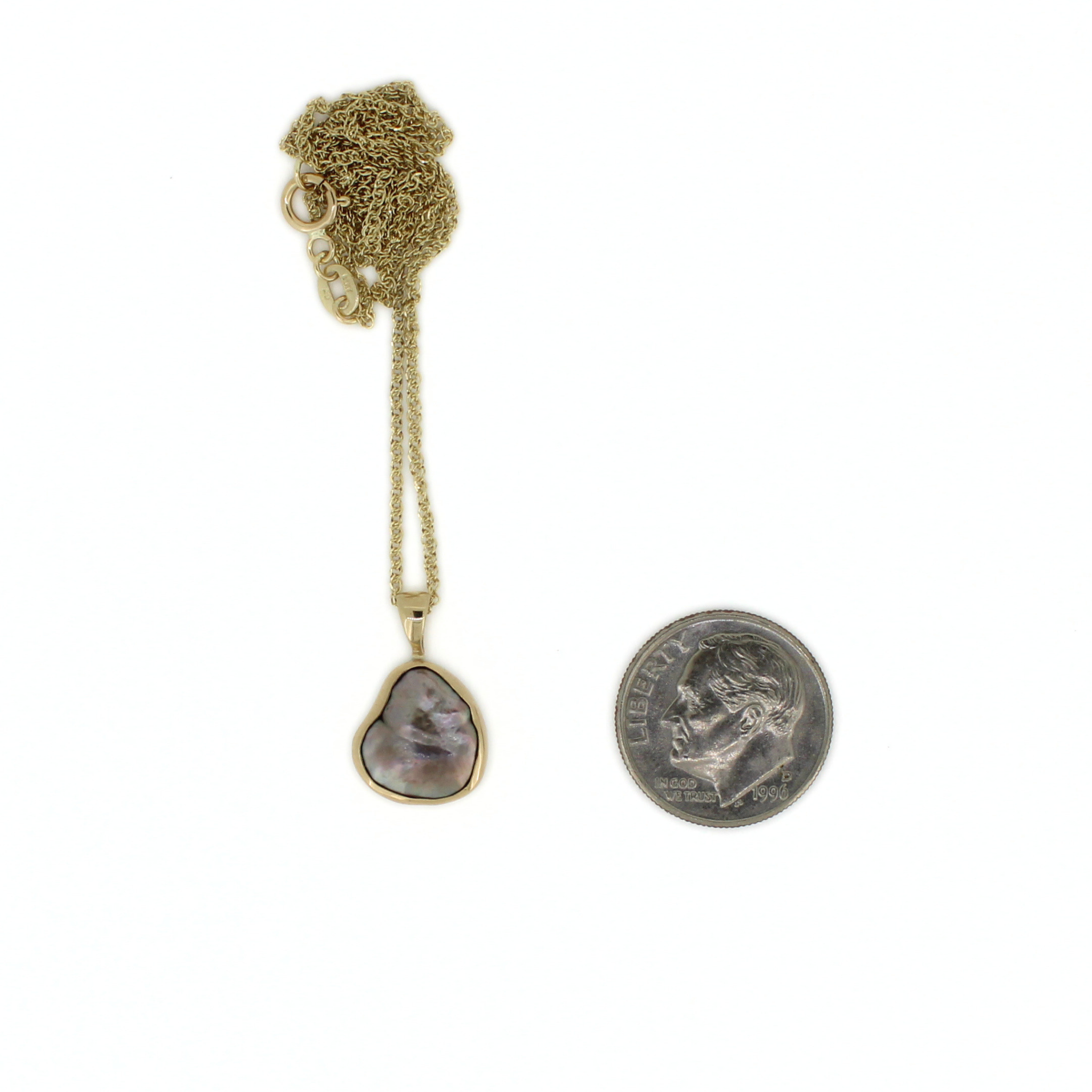 Gold keshi pearl pendant necklace with dark teardrop pearl, shown with coin for scale