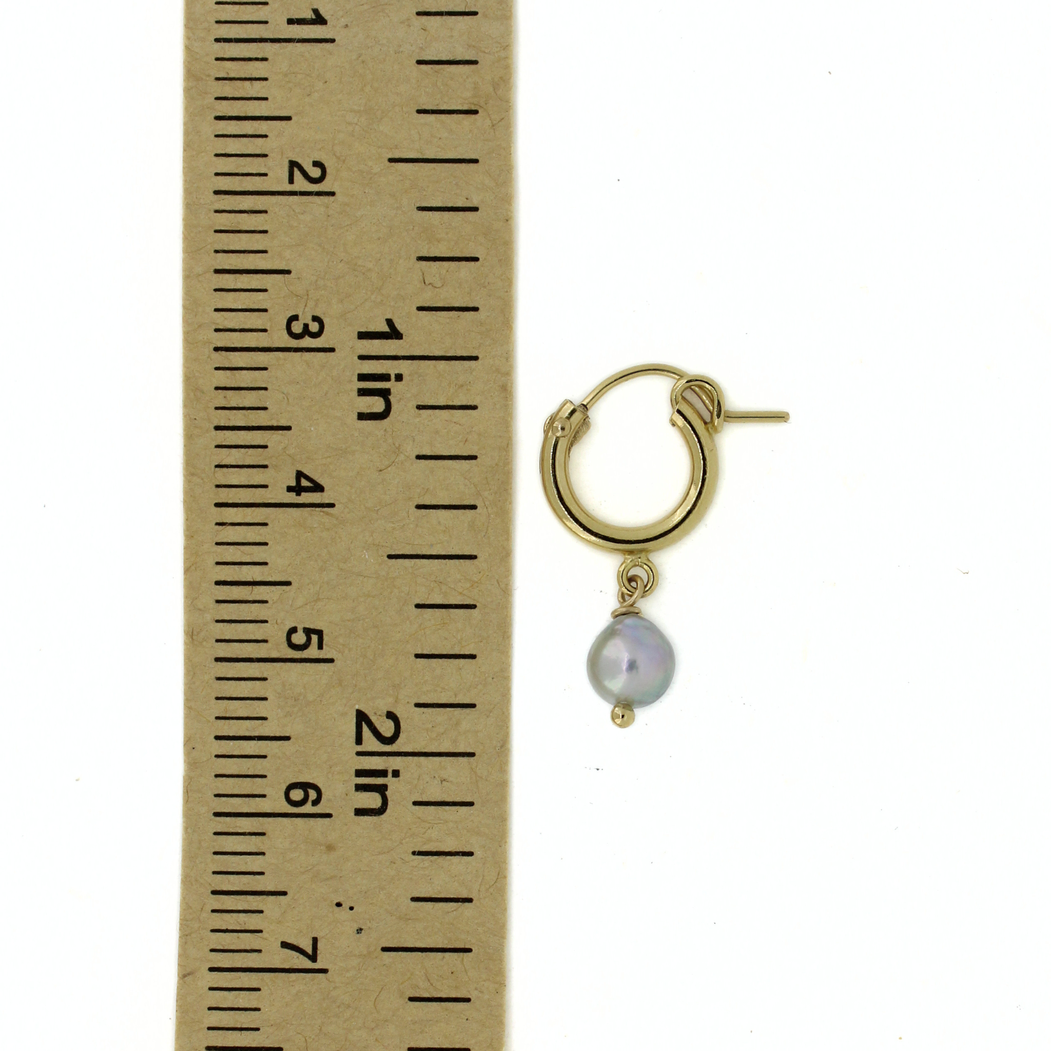 Gold hoop earrings with blue Akoya pearl dangle next to ruler for size