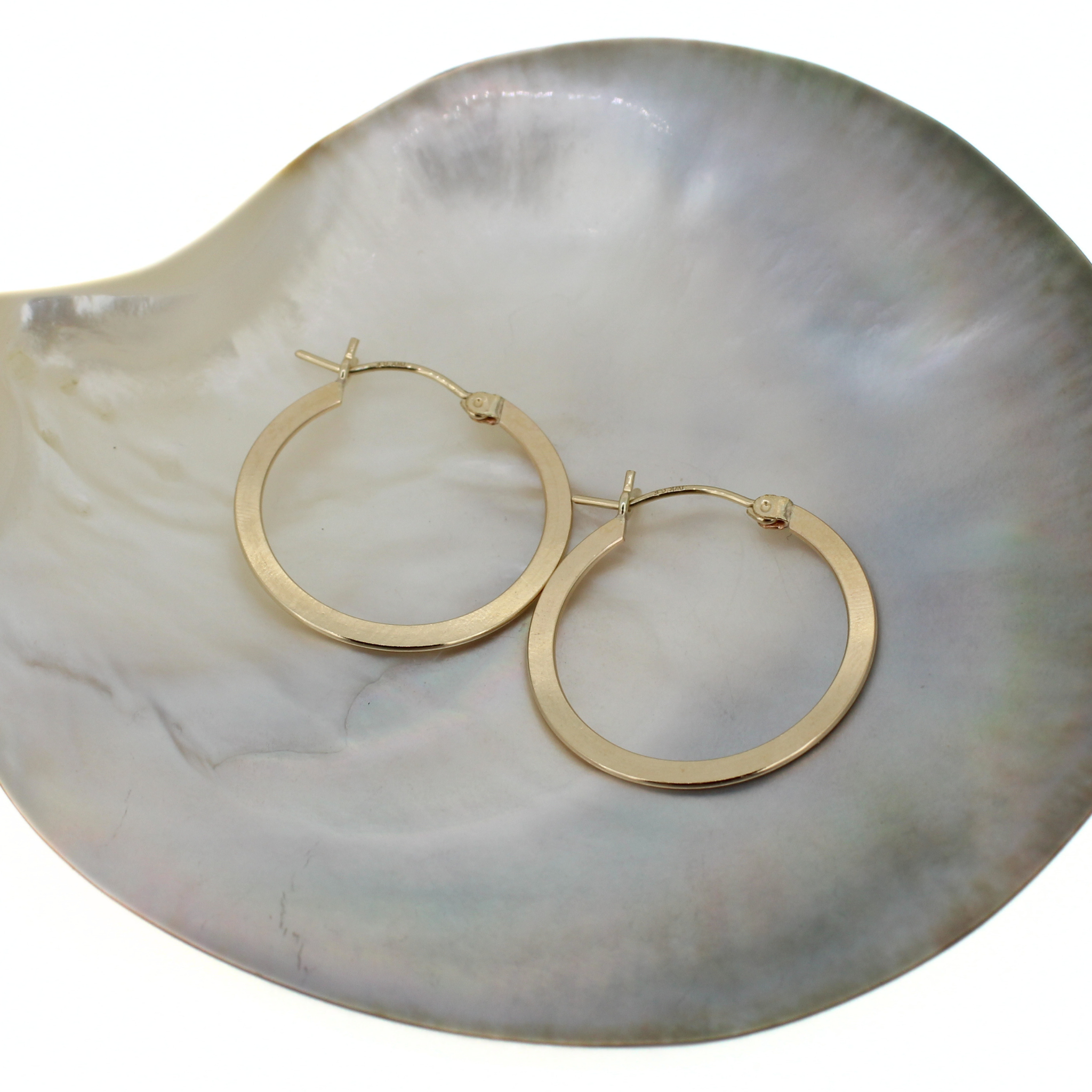 Gold-tone flat hoop earrings, 27mm, with hinge and small charm detail