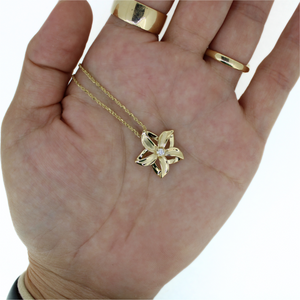 14k cutout flower pendant on 18" chain, shown in hand