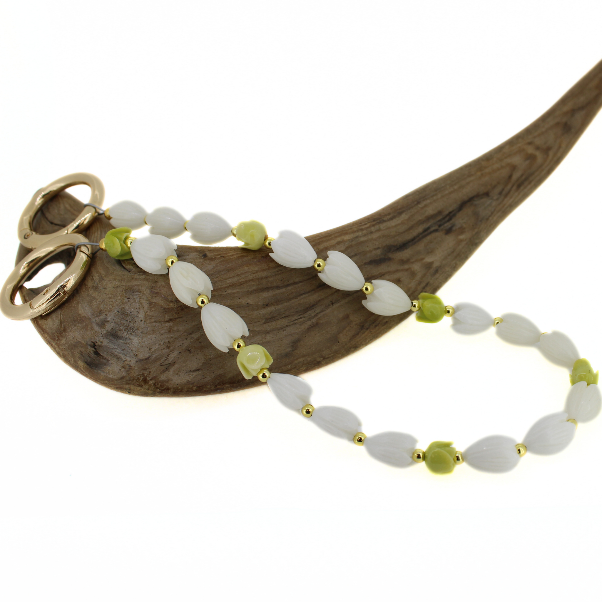 Short floral bead lei with white petal flowers and green accents on wooden stand