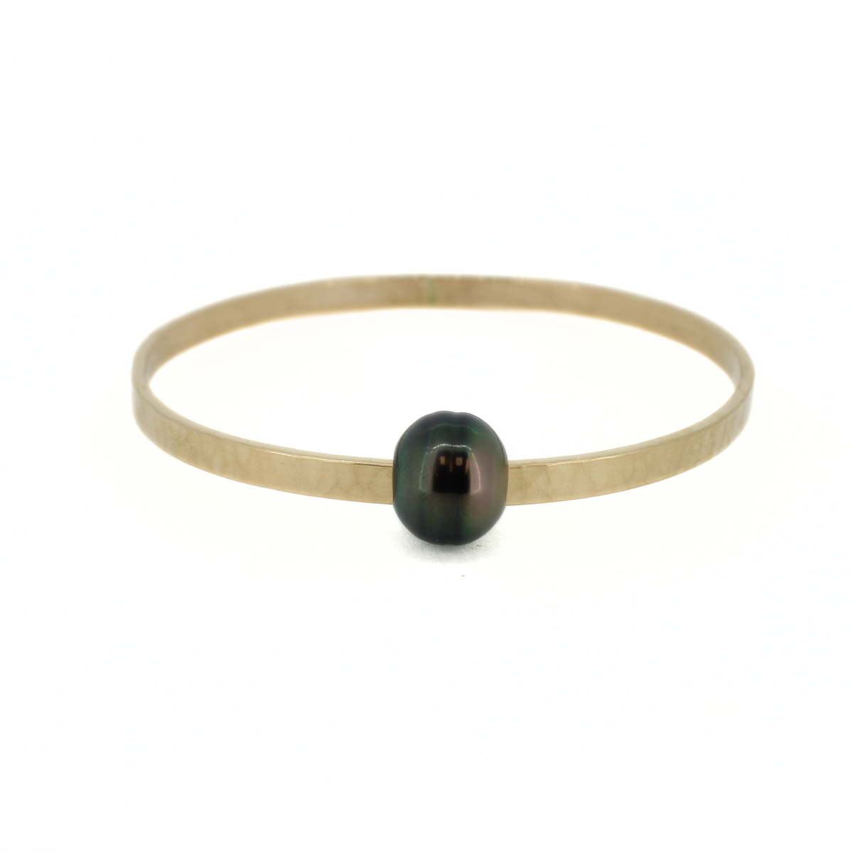 Gold hammered bangle bracelet with a dark Tahitian pearl, shown against a white background