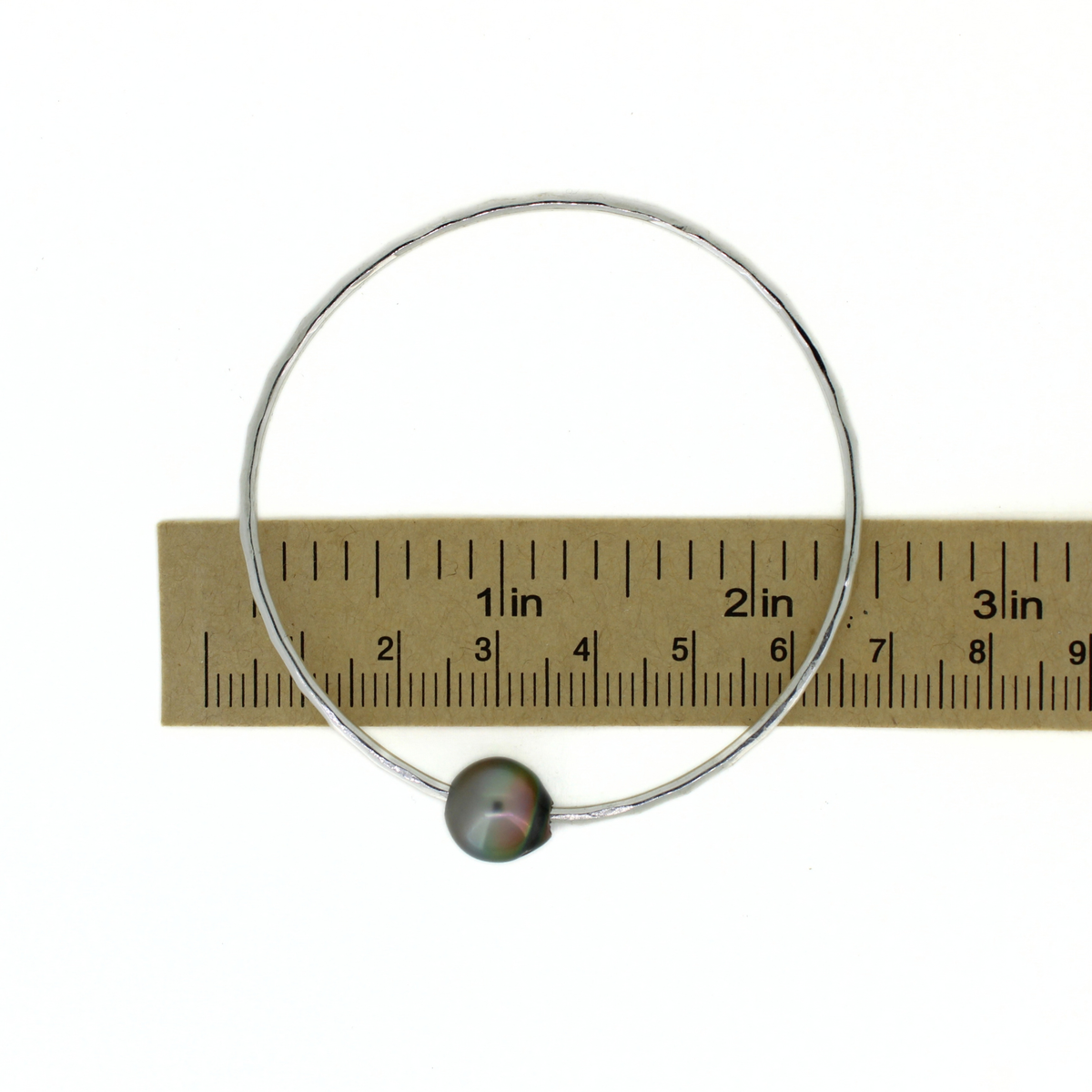 Sterling silver Tahitian pearl round bangle bracelet shown over a ruler for size reference