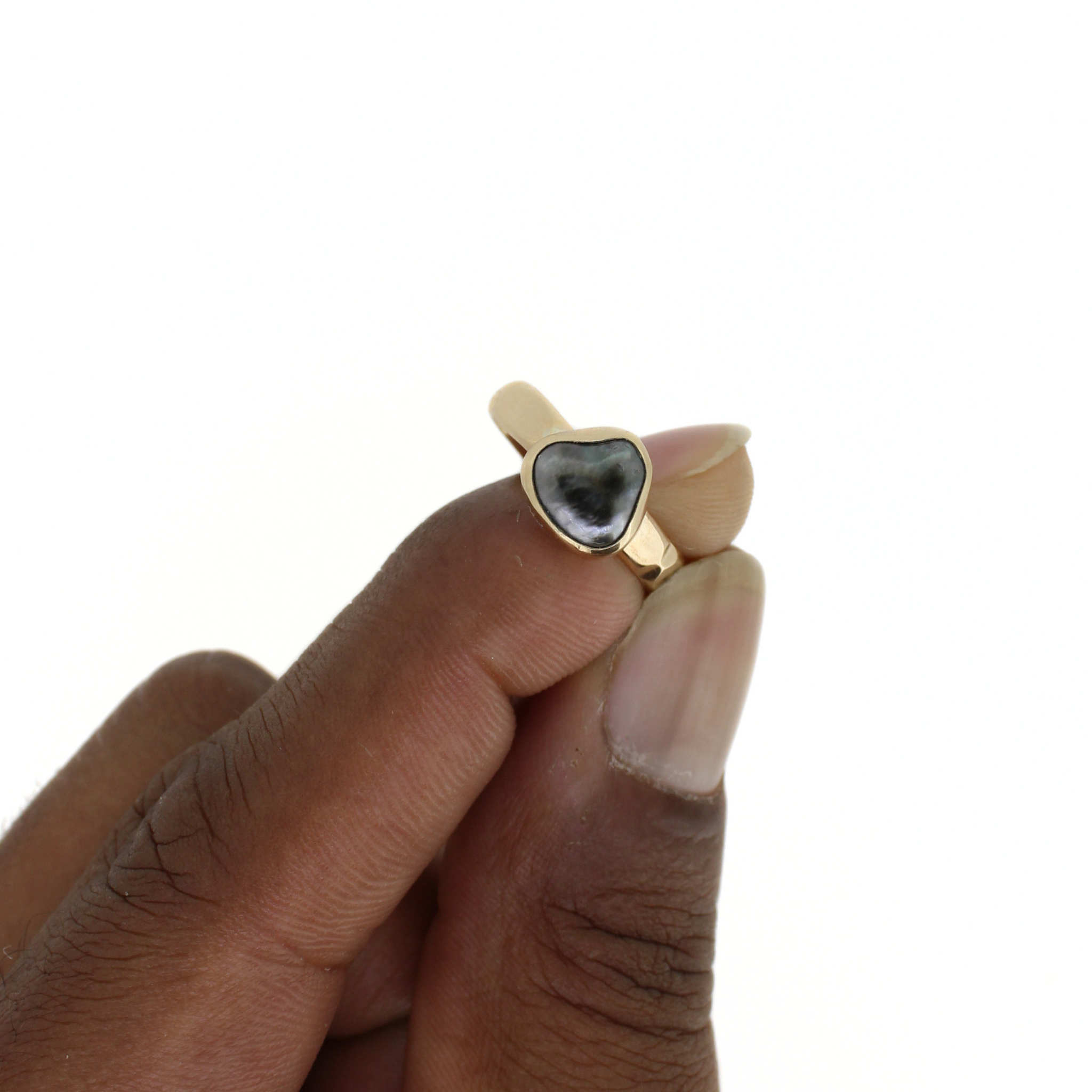 Close-up of gold ring with dark teardrop keshi pearl bezel top view