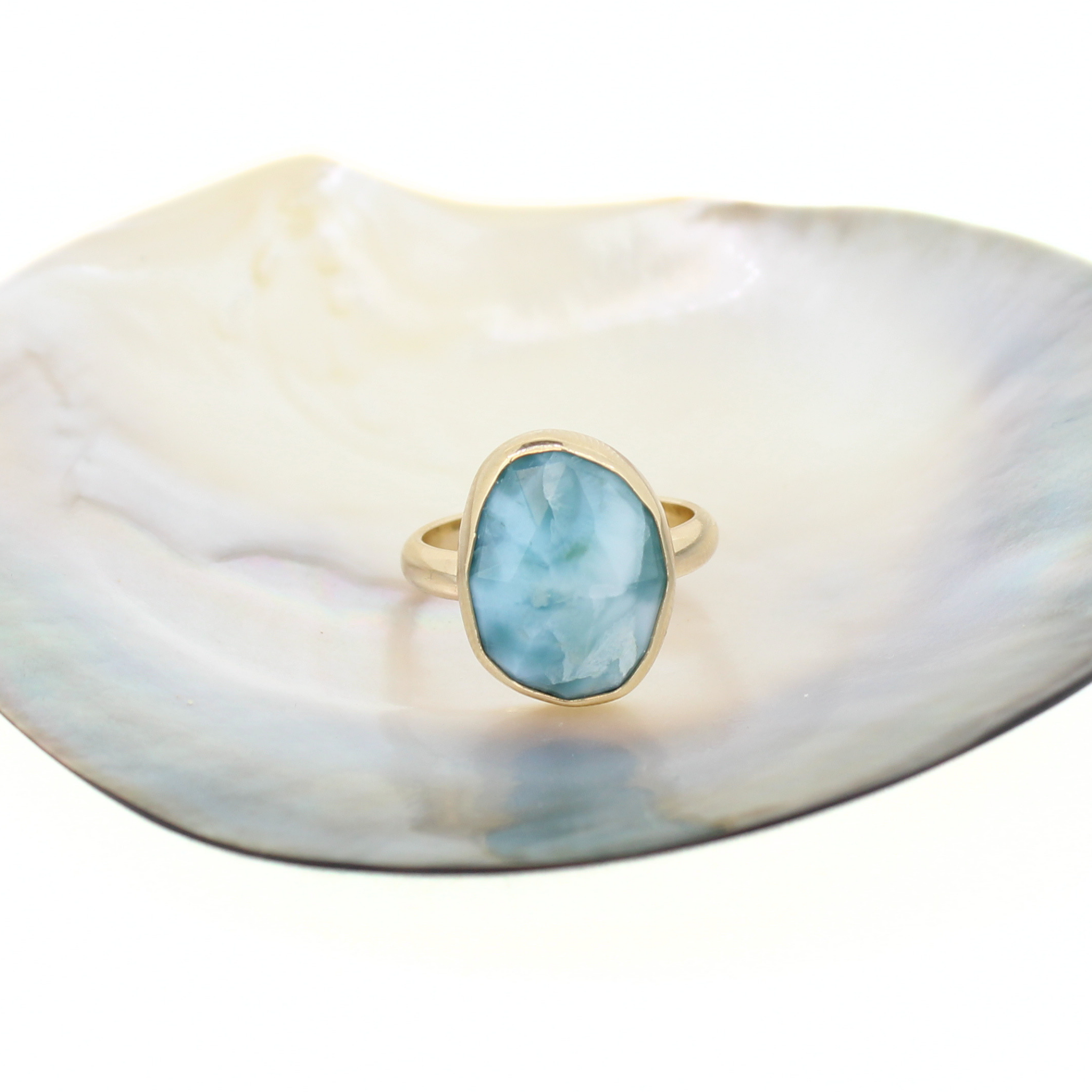 Gold-tone ring with oval blue larimar gemstone bezel setting