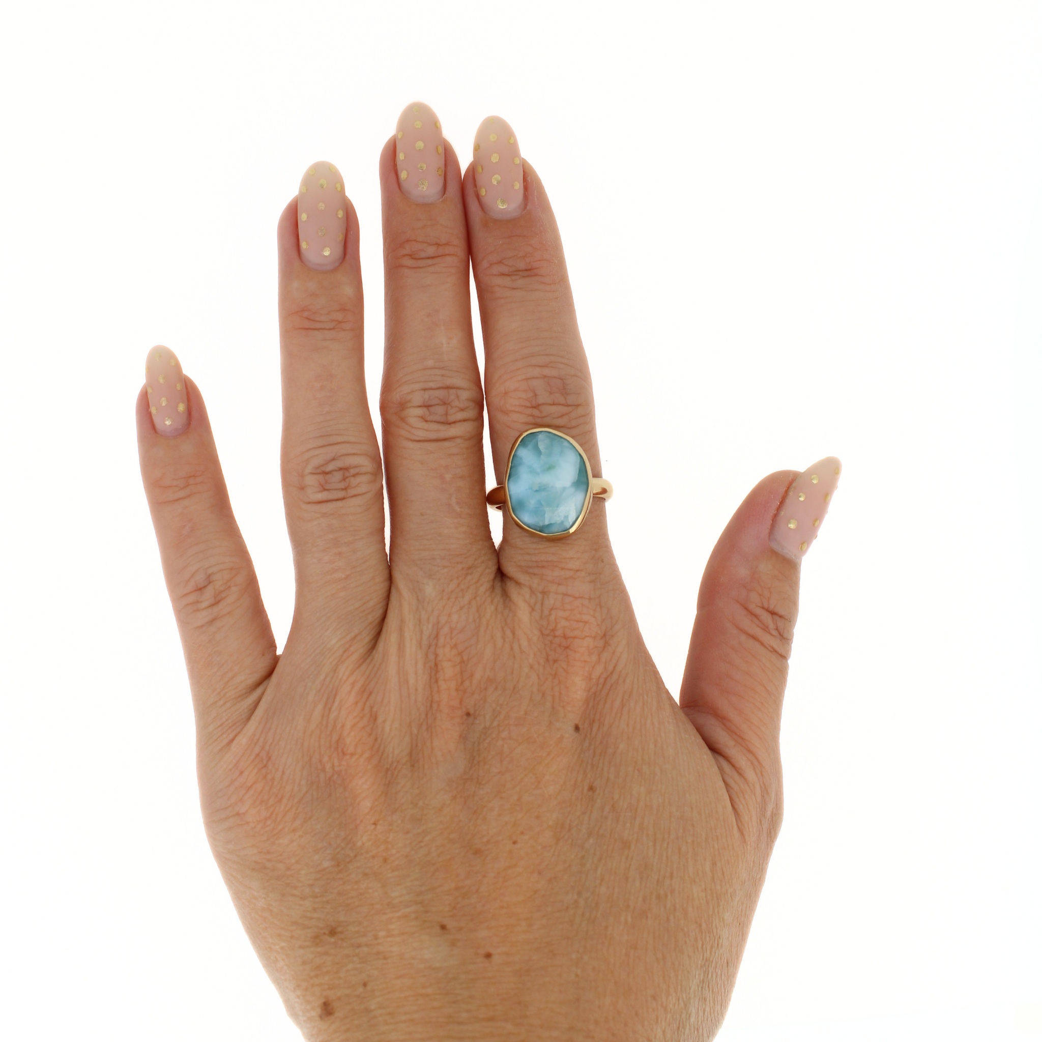 Gold-tone ring with oval blue larimar gemstone on finger