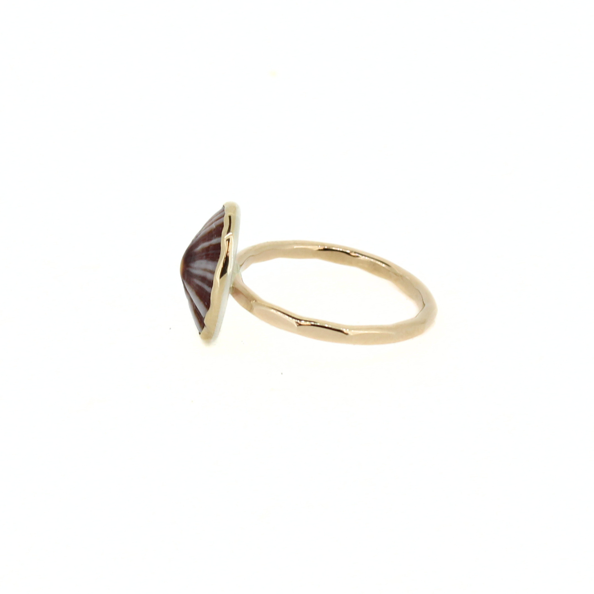 Gold-tone ring side view with maroon radial shell in raised hex bezel
