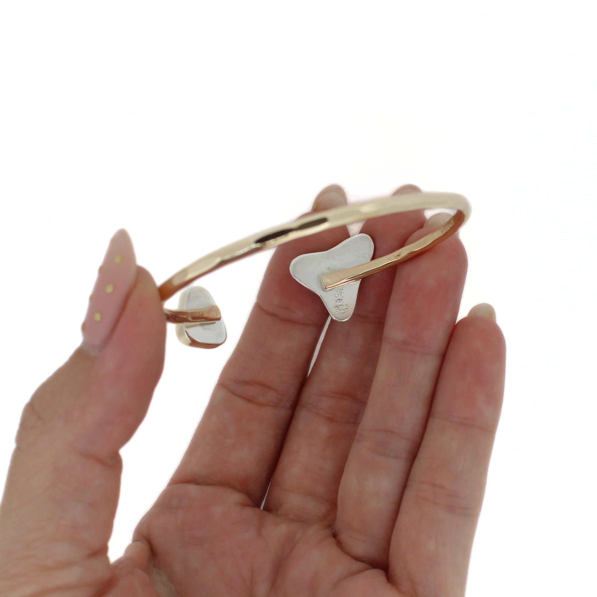 Gold cuff bracelet reverse view with white tooth accent and green sea-glass triangle
