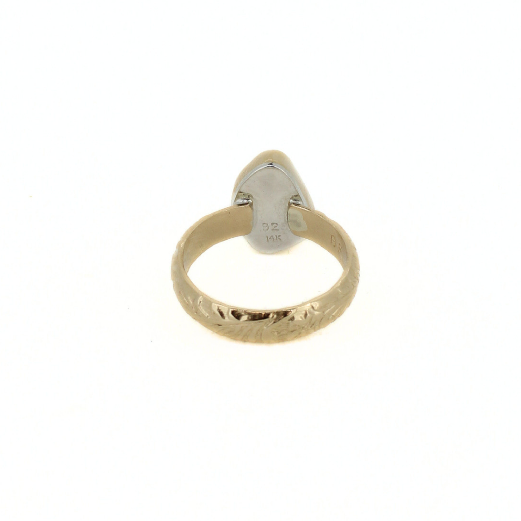 Gold-tone ring with interior stamp “14K” beneath teal sea-glass bezel.