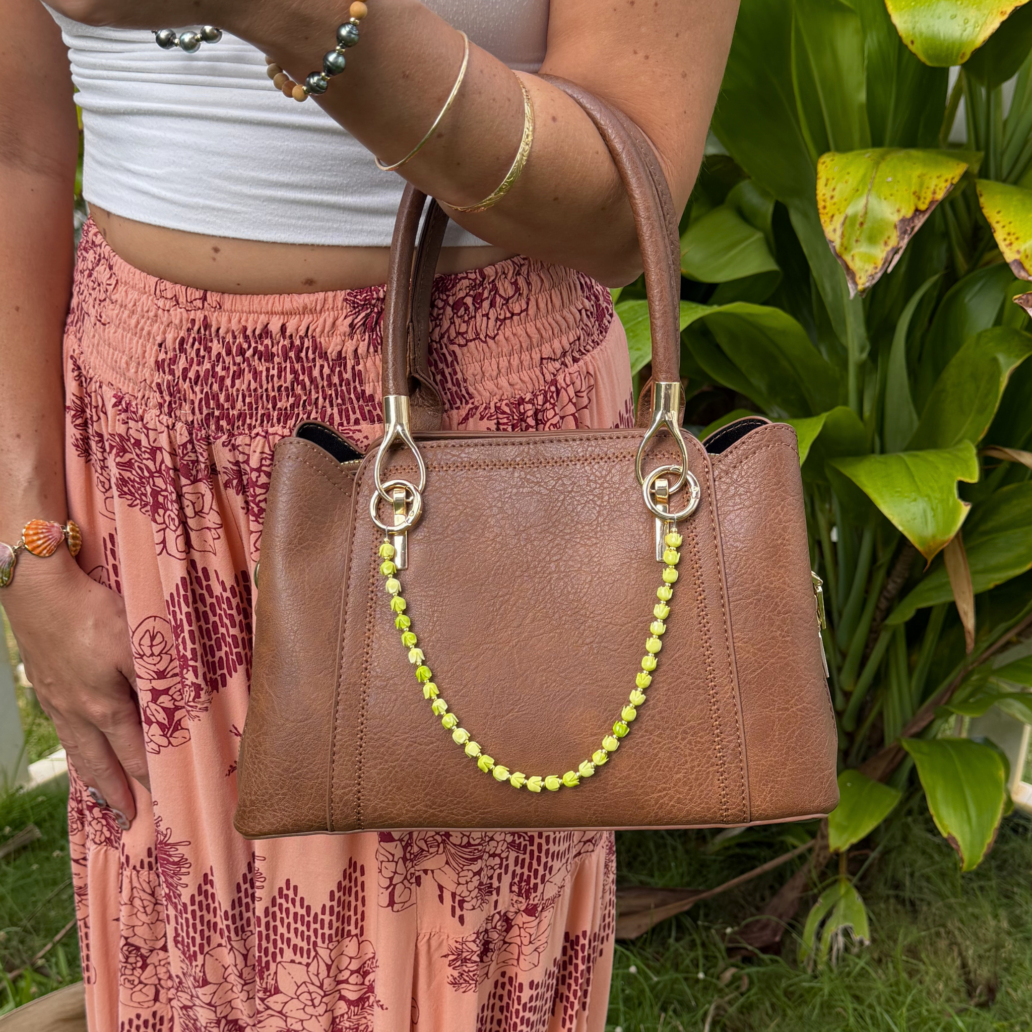 Brown leather-style handbag with lime green flower bead purse lei and gold rings