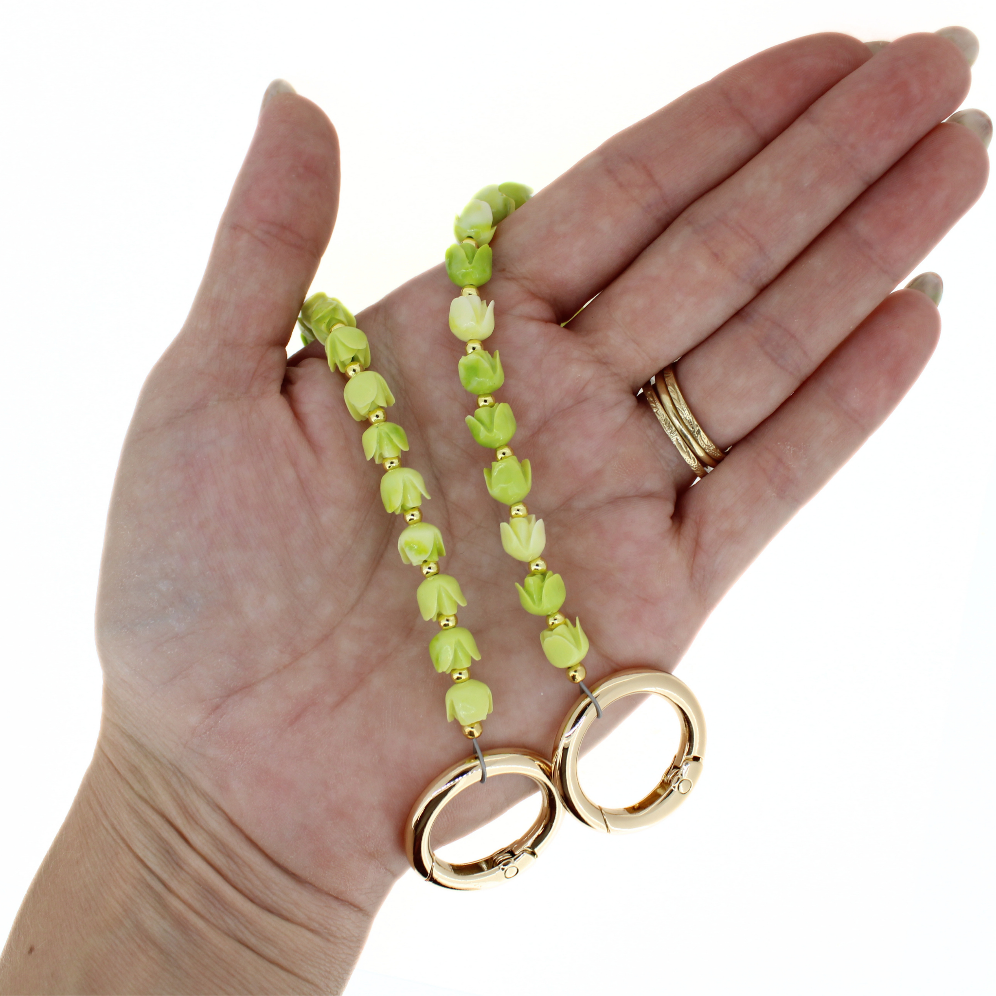 Lime green flower bead purse lei with gold hoop clasps held in palm
