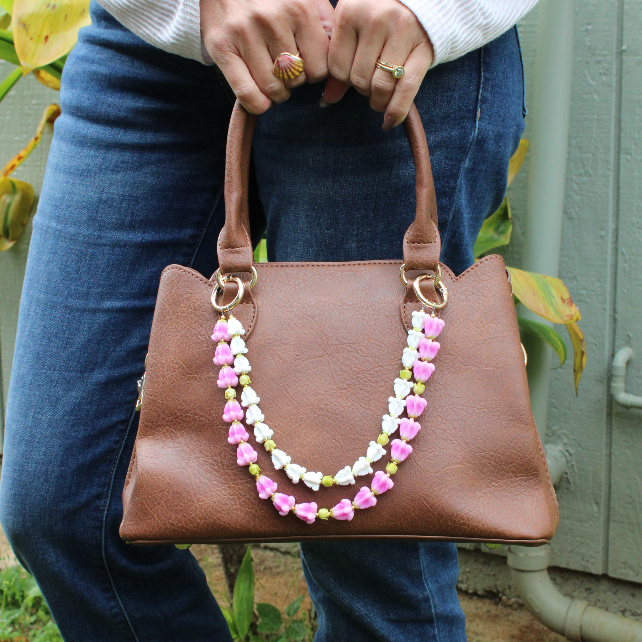 Brianne & Co. purse lei accessory featuring handmade pink and white crown flowers for smaller purses