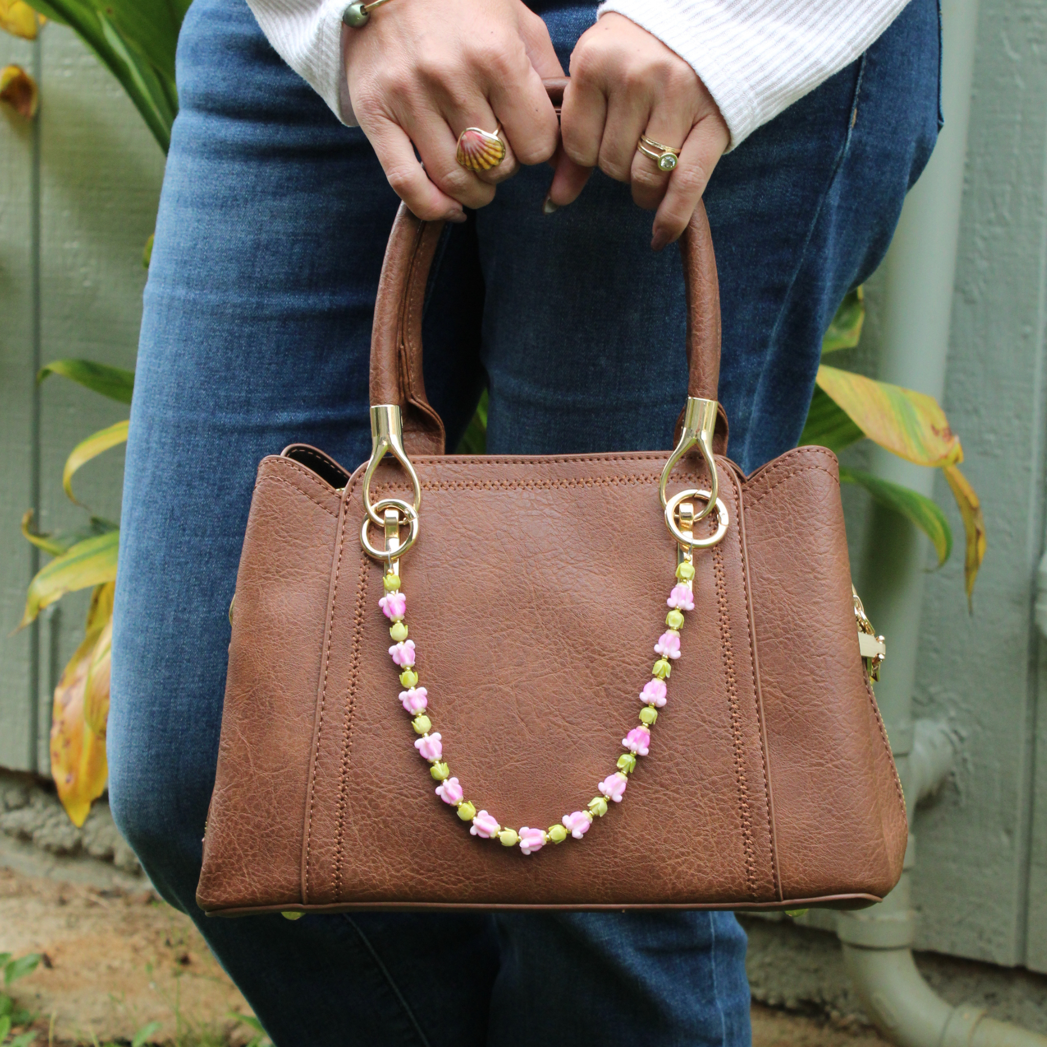 Brianne & Co. purse leii accessory featuring pink clay crown flowers and green resin pakalana blossoms for smaller handbags