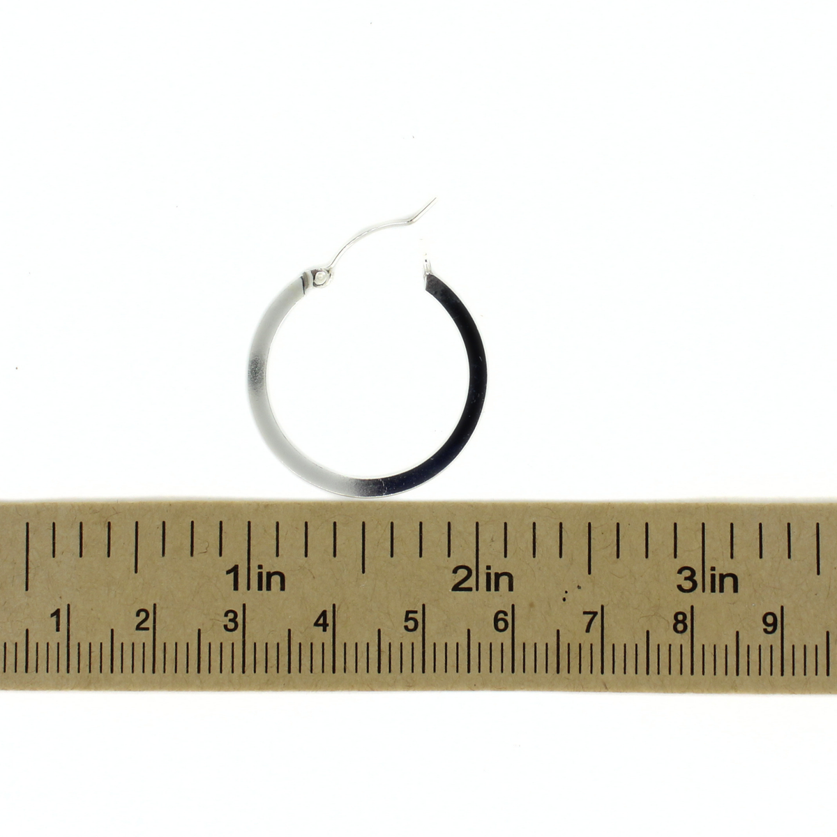 Sterling silver hoop earrings next to a ruler for size reference