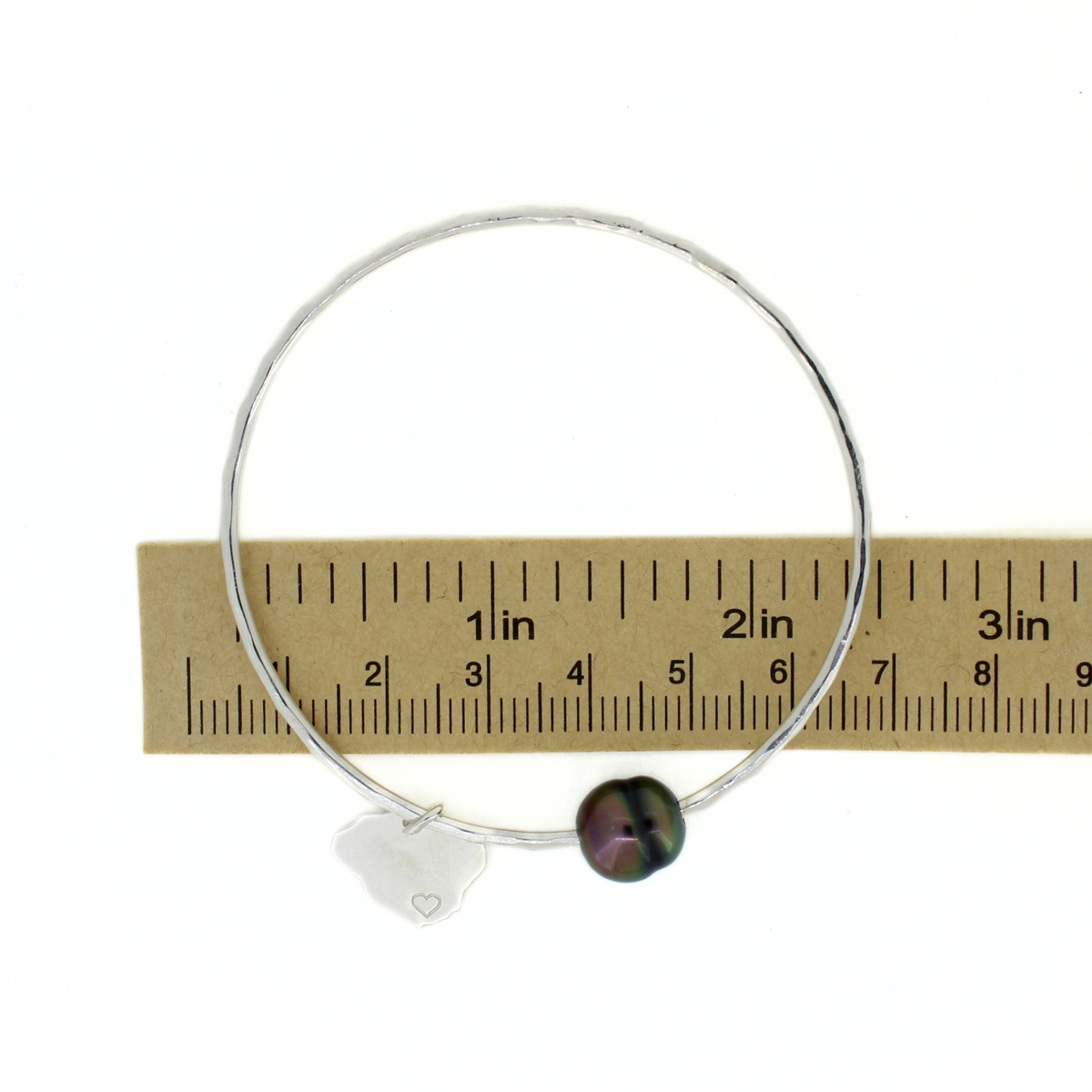 Sterling silver round Tahitian pearl bangle shown over a ruler for size reference