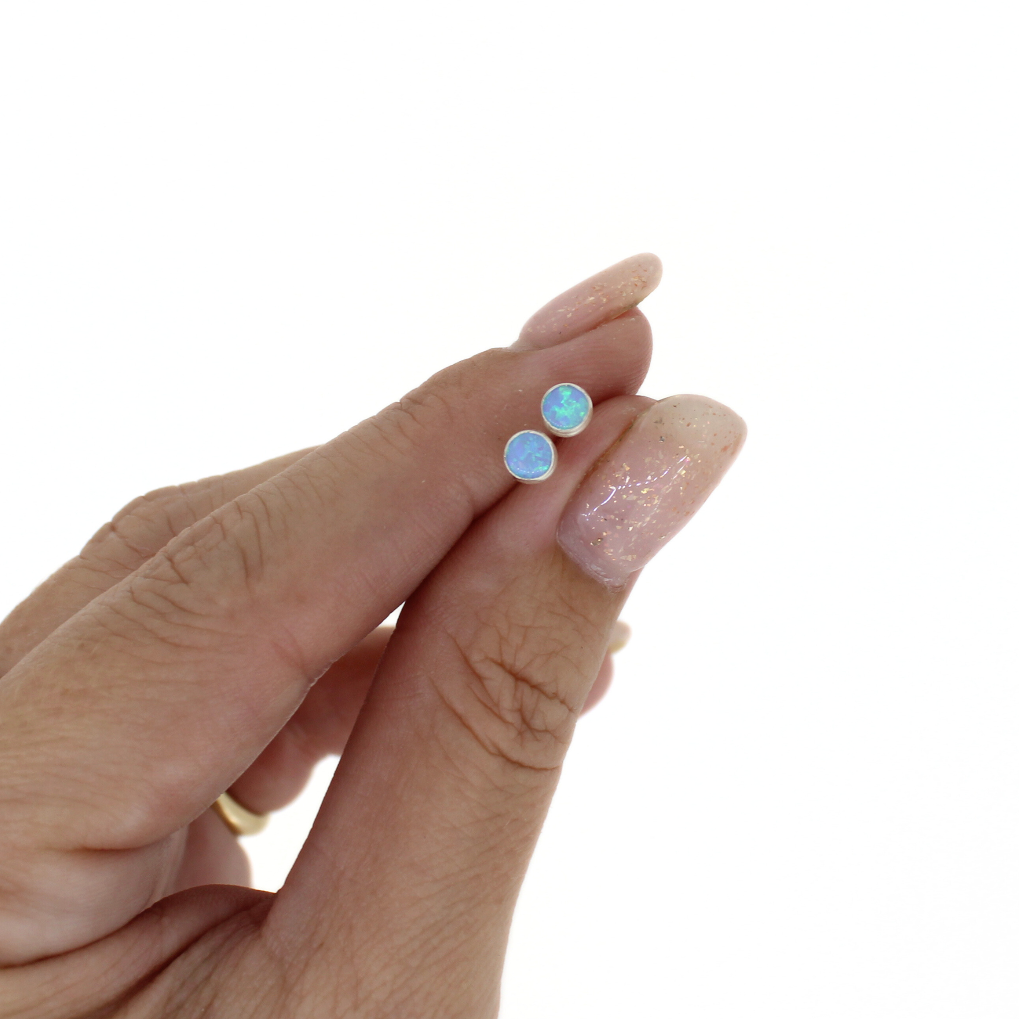 Brianne & Co. sterling silver light blue mini simulated opal stud earrings in hand for size reference