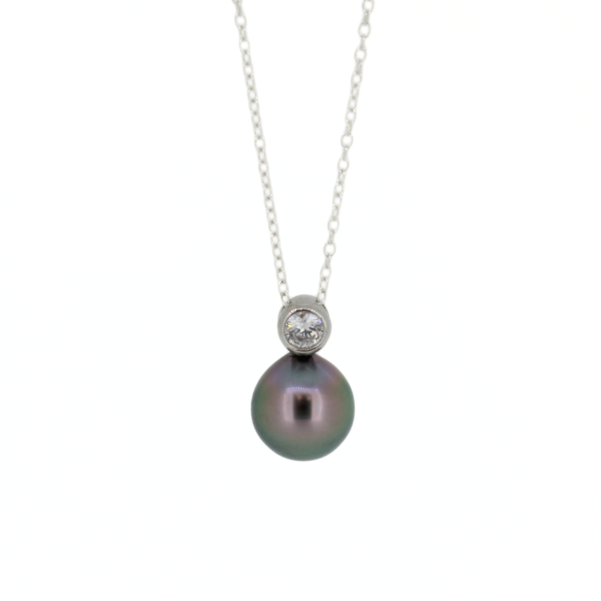 A silver necklace featuring a round dark gray pearl pendant and a small bezel-set clear cubic zirconia above it, suspended from a delicate silver chain against a plain white background.