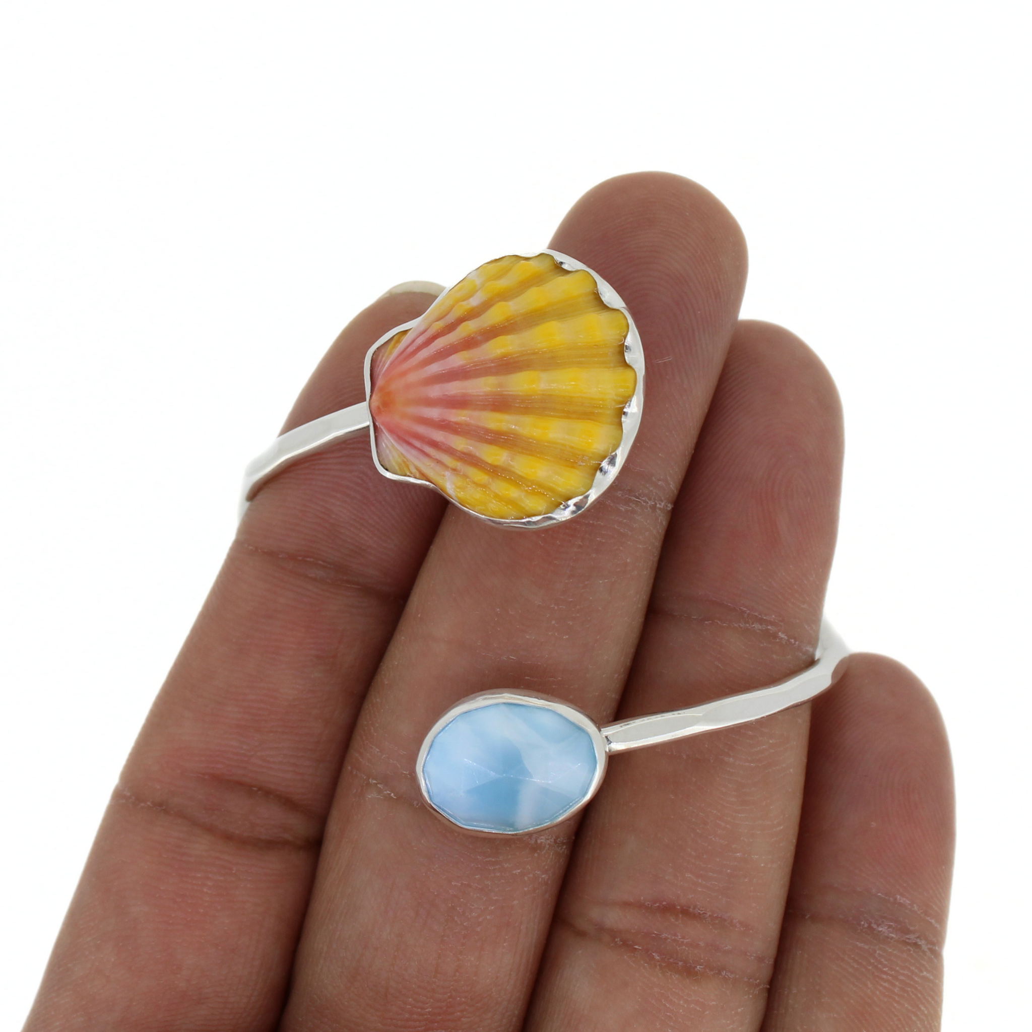 Sterling silver cuff detail: scalloped shell top and blue oval larimar on bypass arms