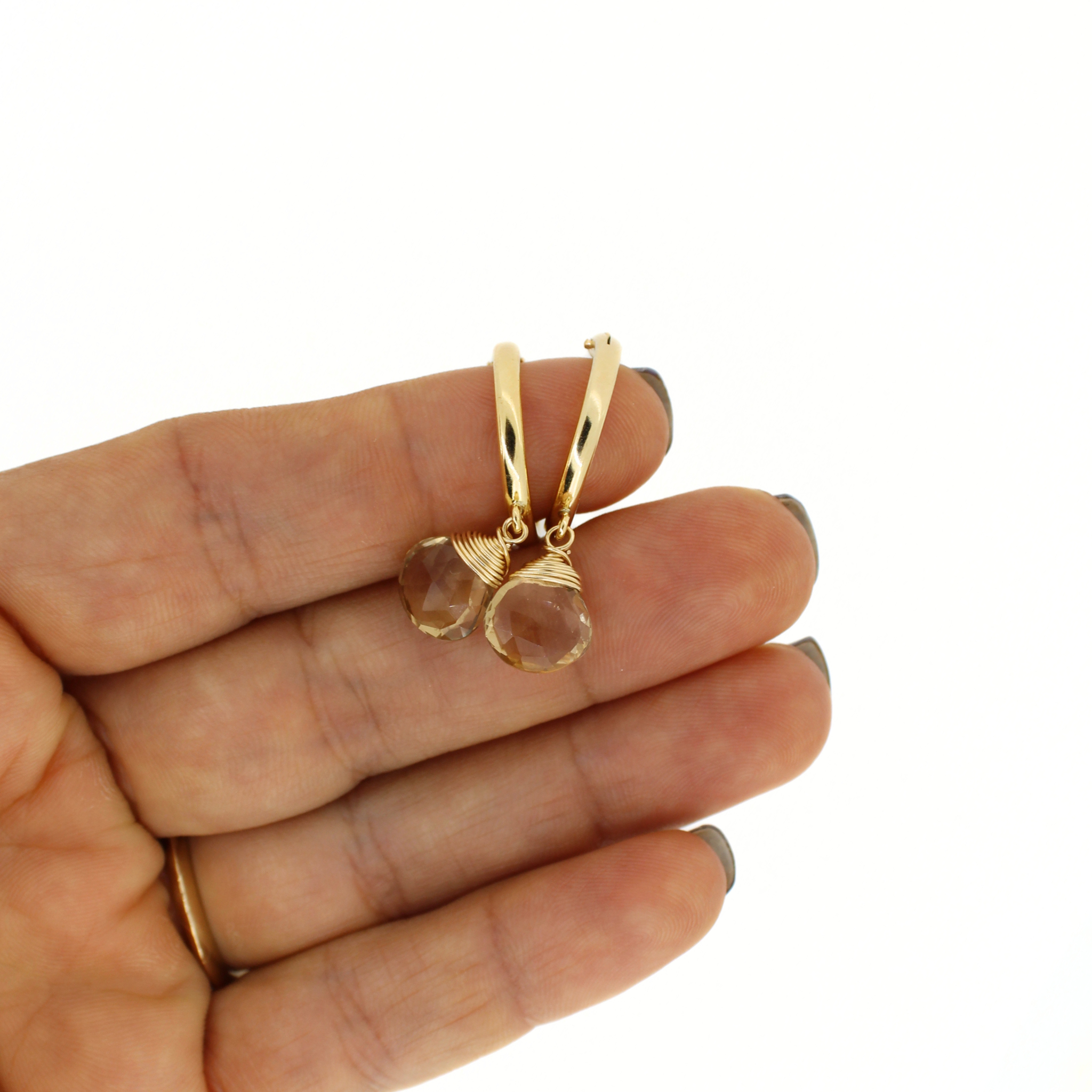 Gold hoop earrings with faceted champagne topaz dangle charms, side view