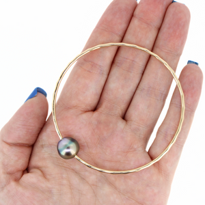Brianne & Co gold fill bangle with pear shaped Tahitian pearl, shown in hand