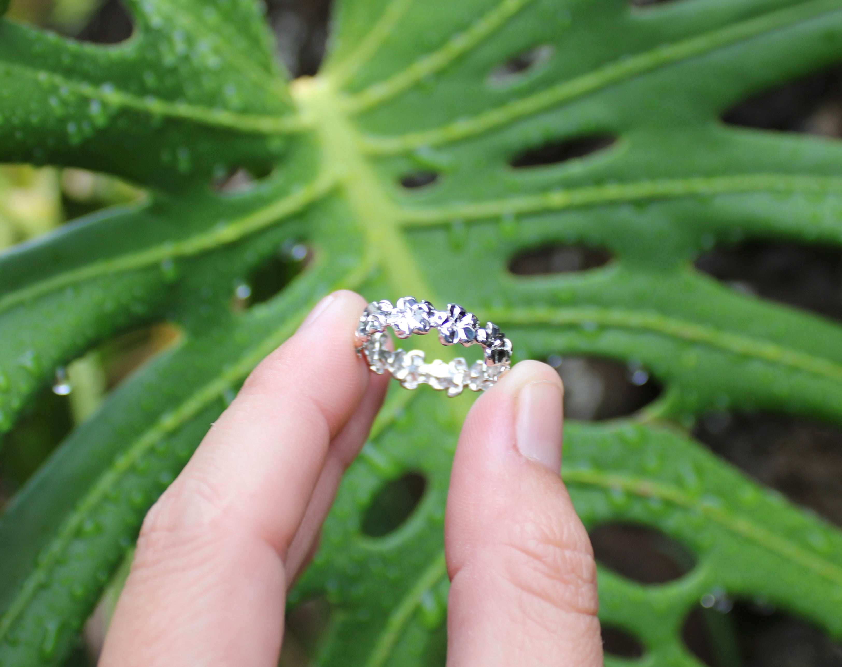 Sterling silver plumeria band ring with a gemstone flower centerpiece and pavé band