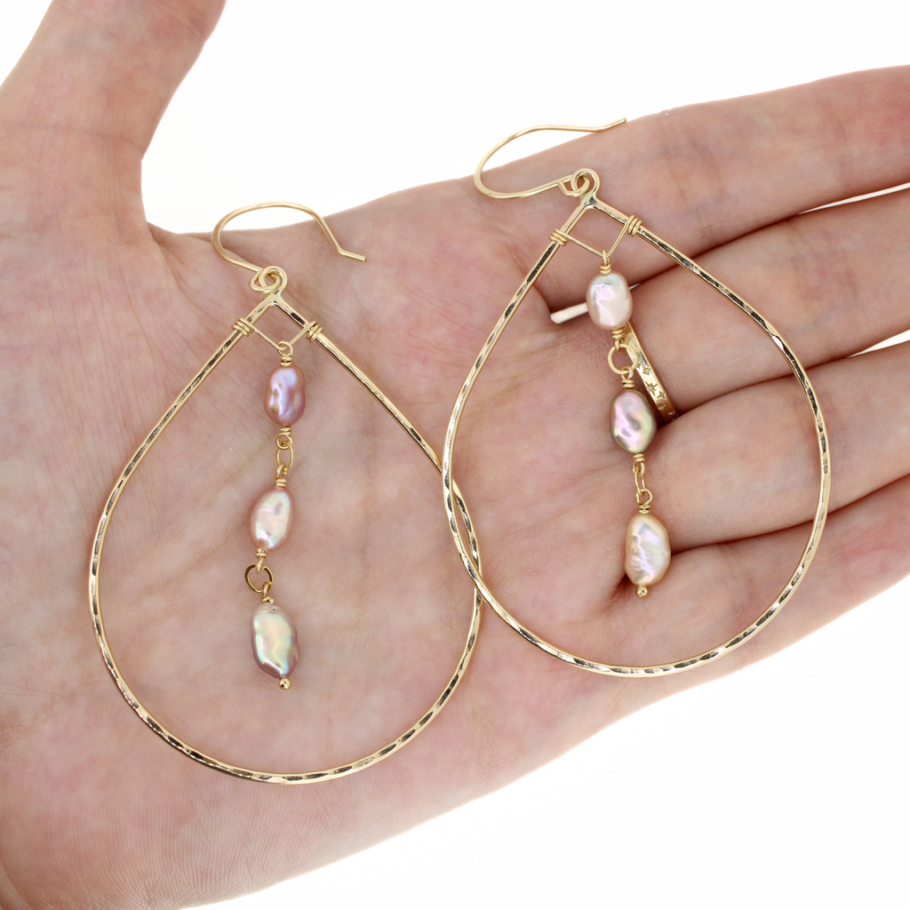 Brianne & Co. medium gold teardrop hoop earrings with Edison keshi pearls on hand