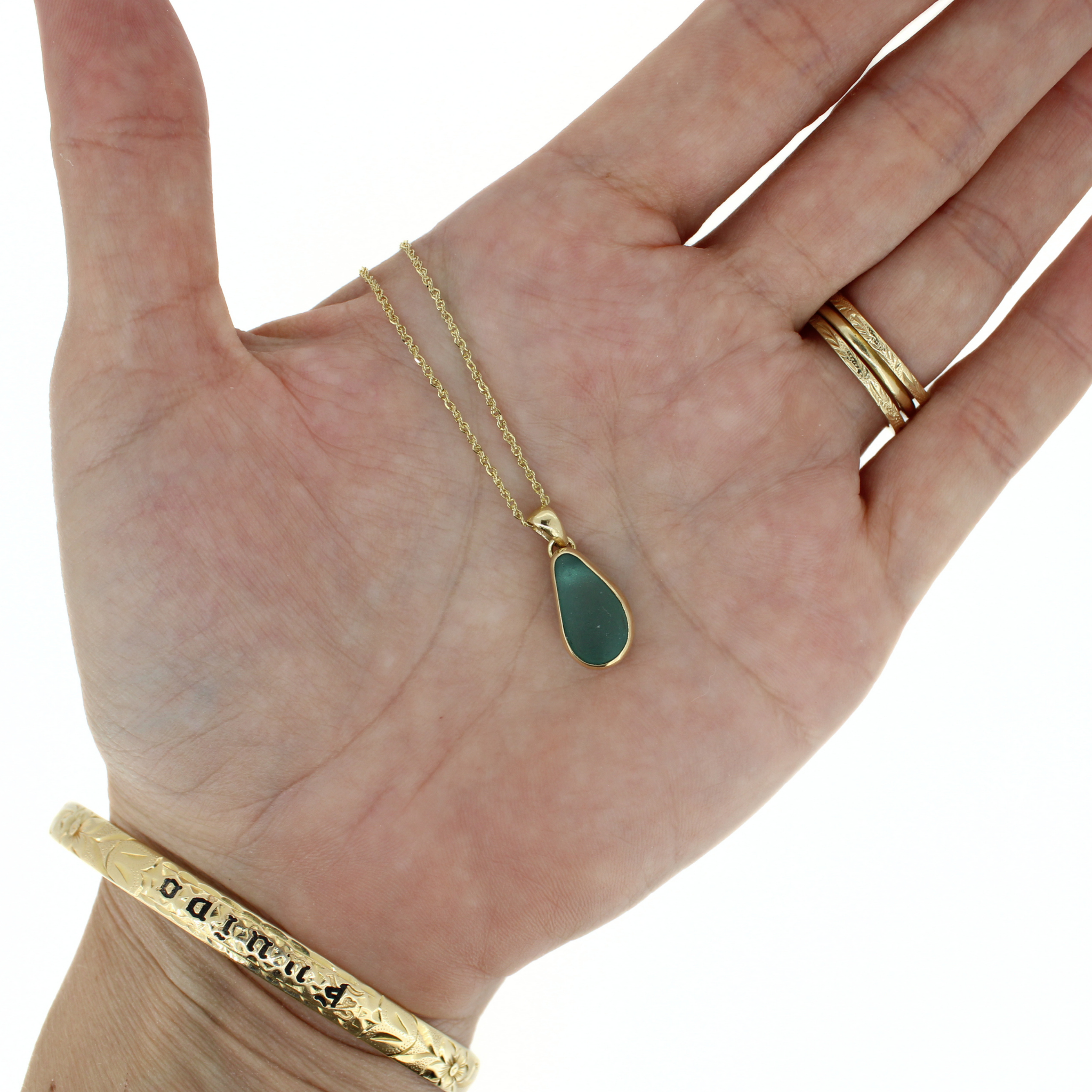 Gold teardrop sea glass pendant necklace on open hand