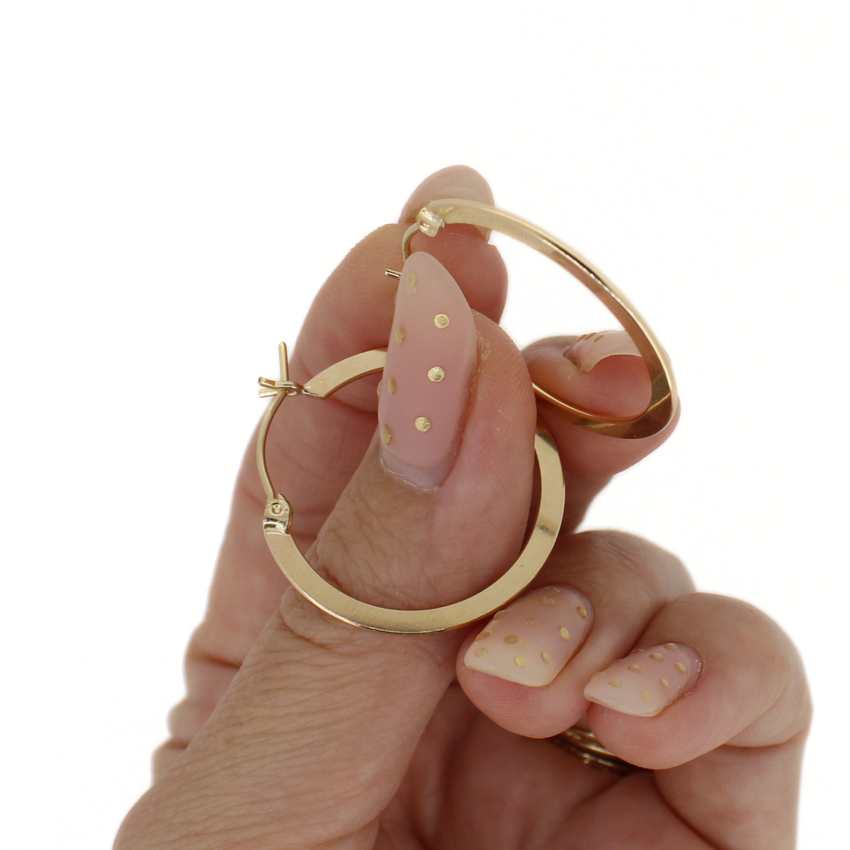 Gold-tone flat hoop earrings, 27mm, held up; hinge and clasp detail visible