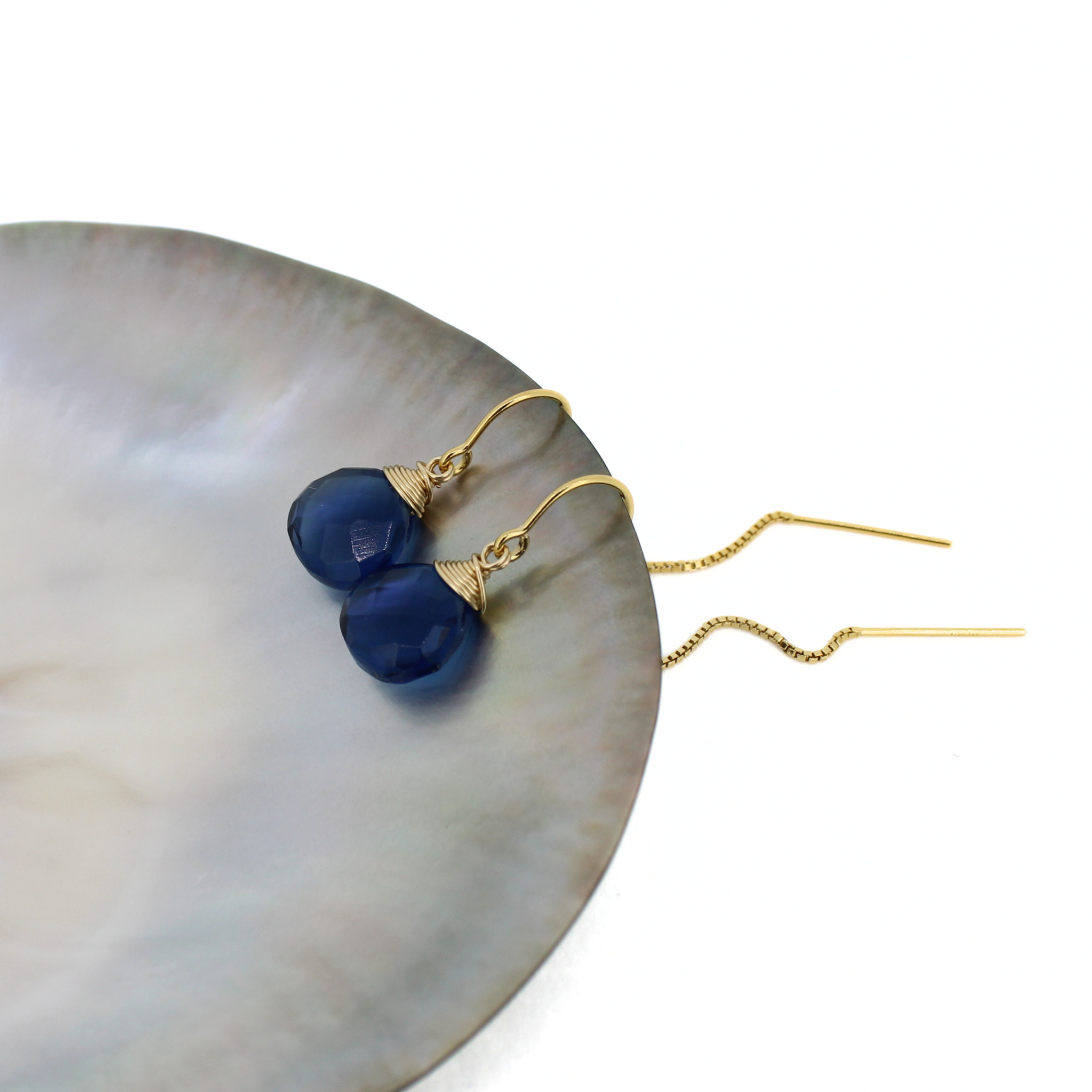 Gold-tone threader earrings with blue faceted teardrop stones and chain