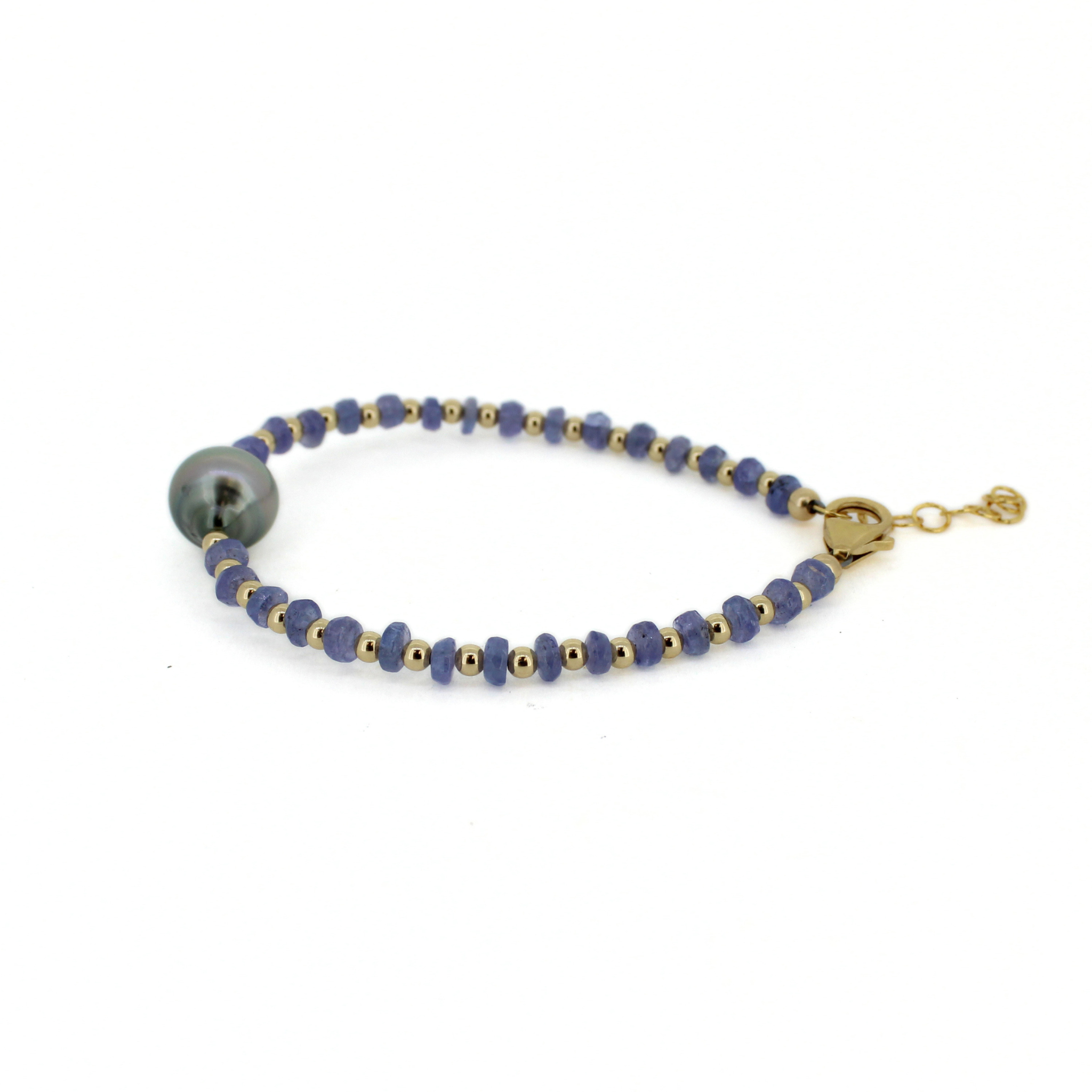 Side view of gold bracelet: dark blue beads with gray baroque pearls and small gold clasp.