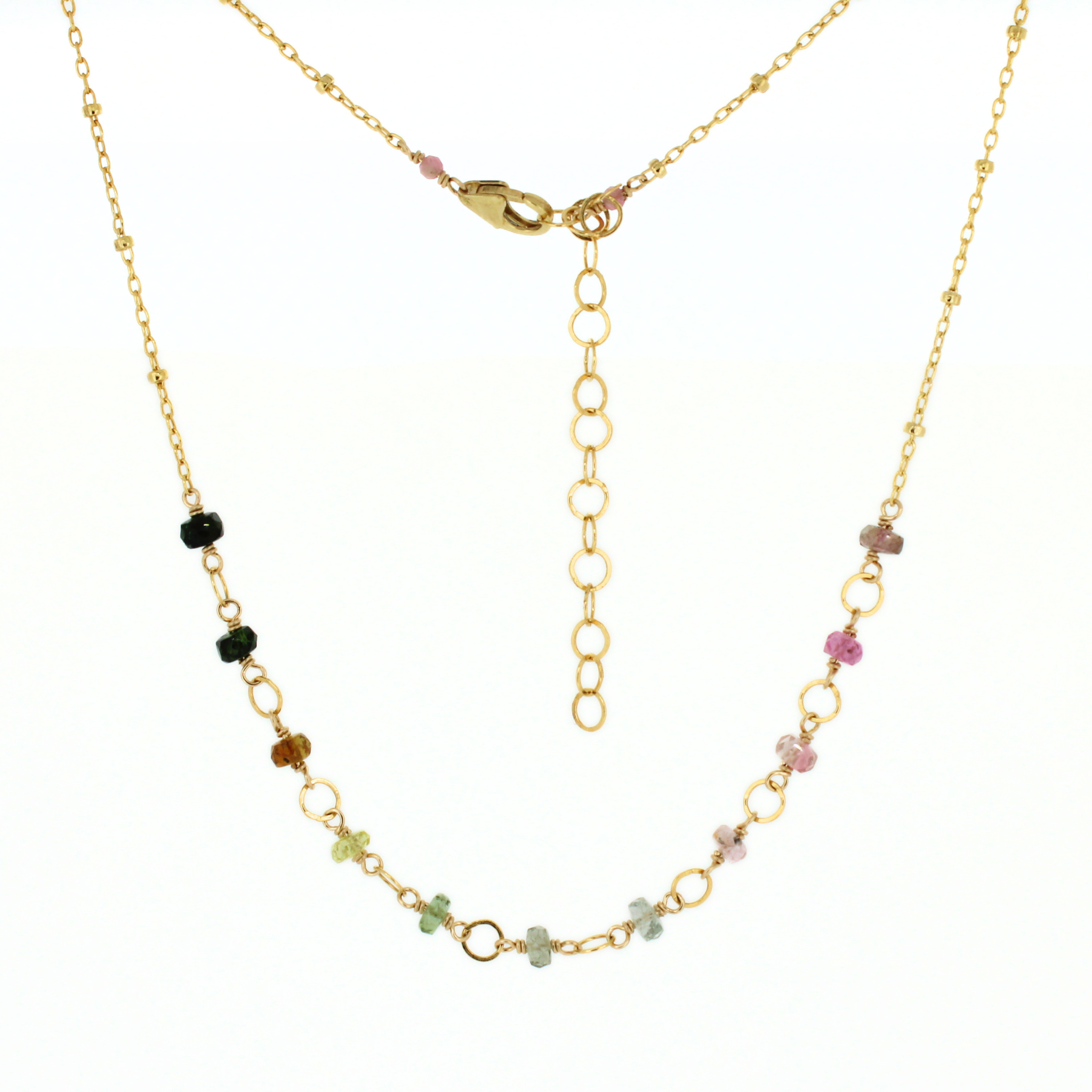 A delicate gold chain necklace featuring small, colorful gemstone beads in pink, green, brown, and black, displayed against a solid white background.