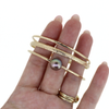 14k gold fill triple bangle set featuring a delicate hammered bangle, our popular floral bangle, and a stunning deep purple Edison pearl bangle. Handmade by Brianne & Co.
