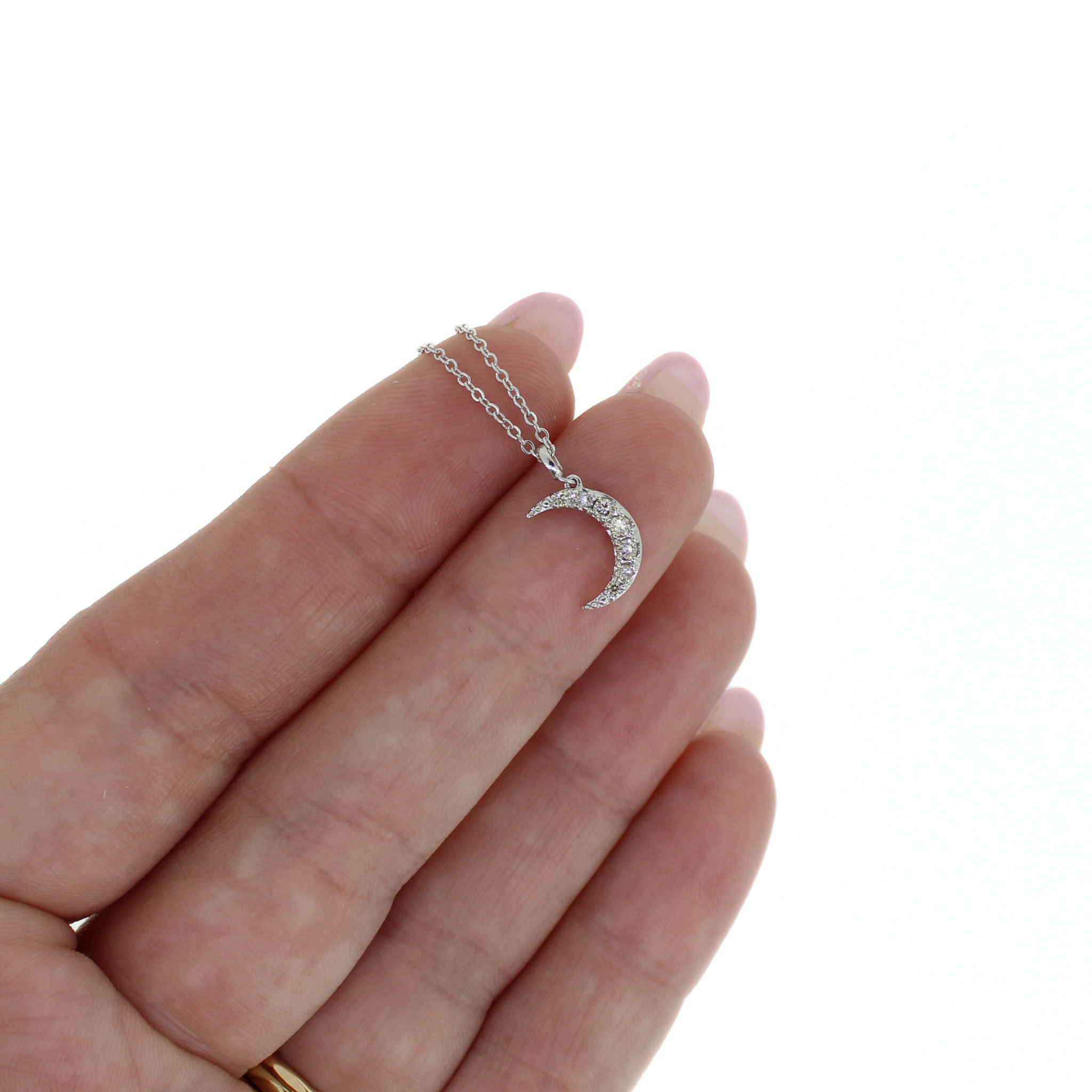 Brianne & Co. 14k white gold diamond moon necklace on finger for size reference