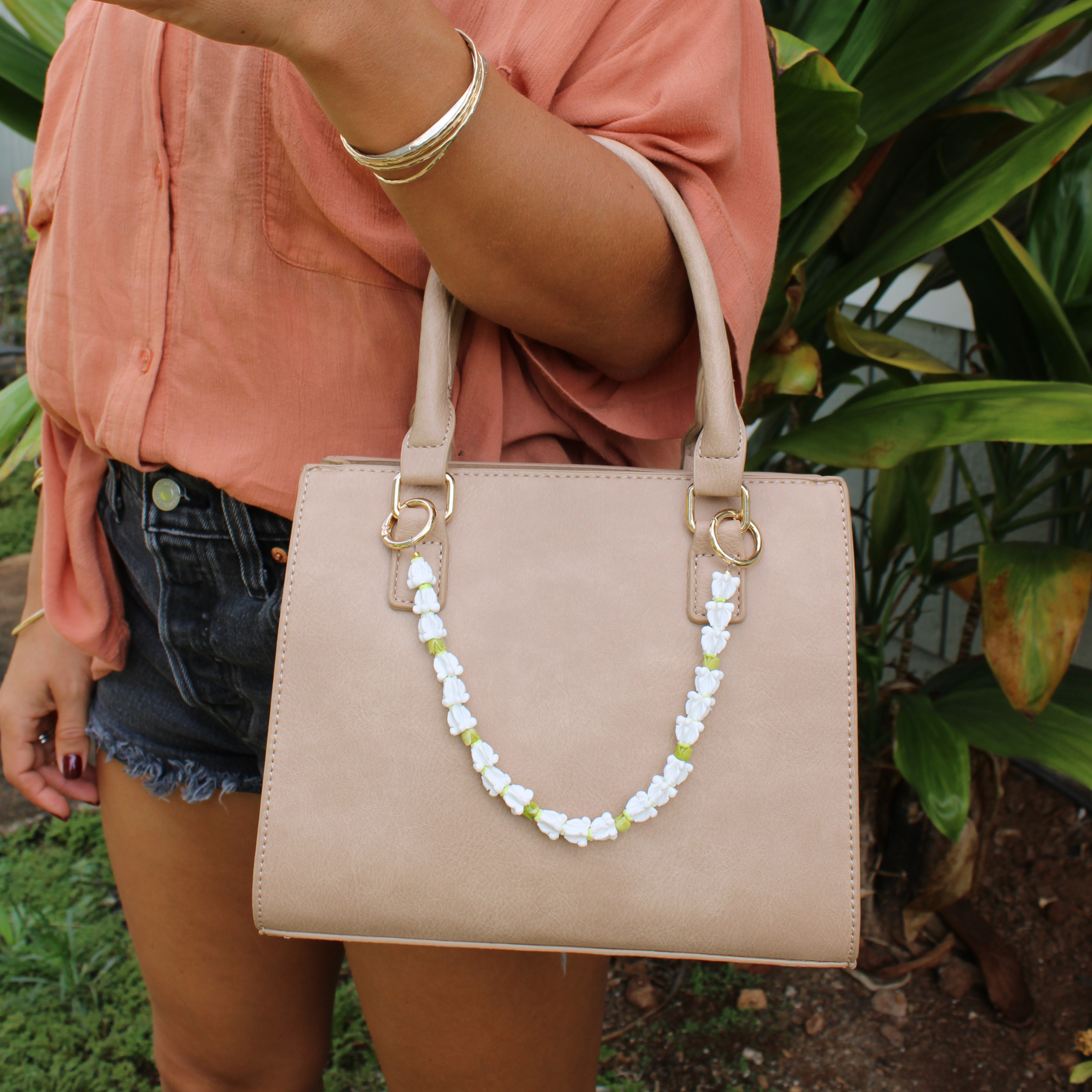 Brianne & Co. white crown flower and green pakalana flower purse lei