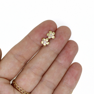 Brianne & Company 14k gold diamond plumeria studs in hand