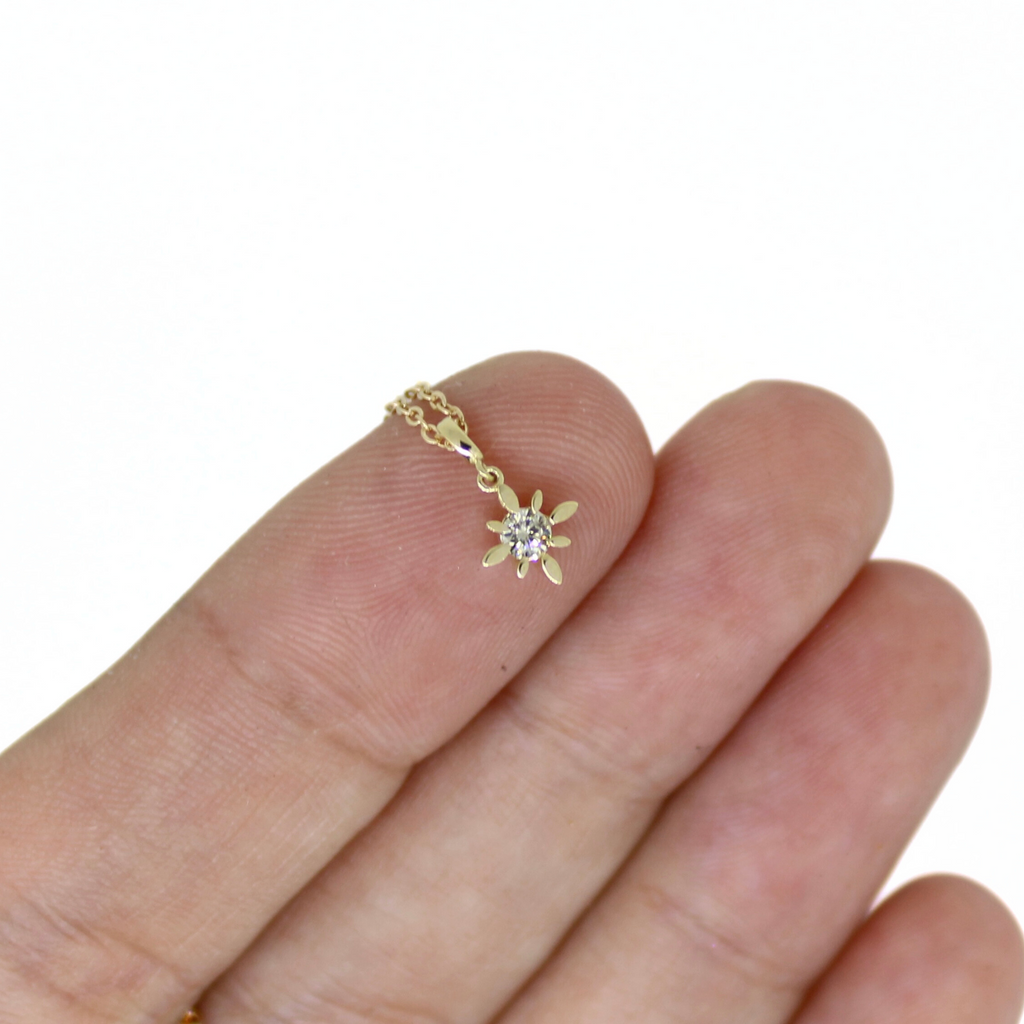 Brianne & Co. 14k tiny yellow 14k gold diamond star pendant on finger