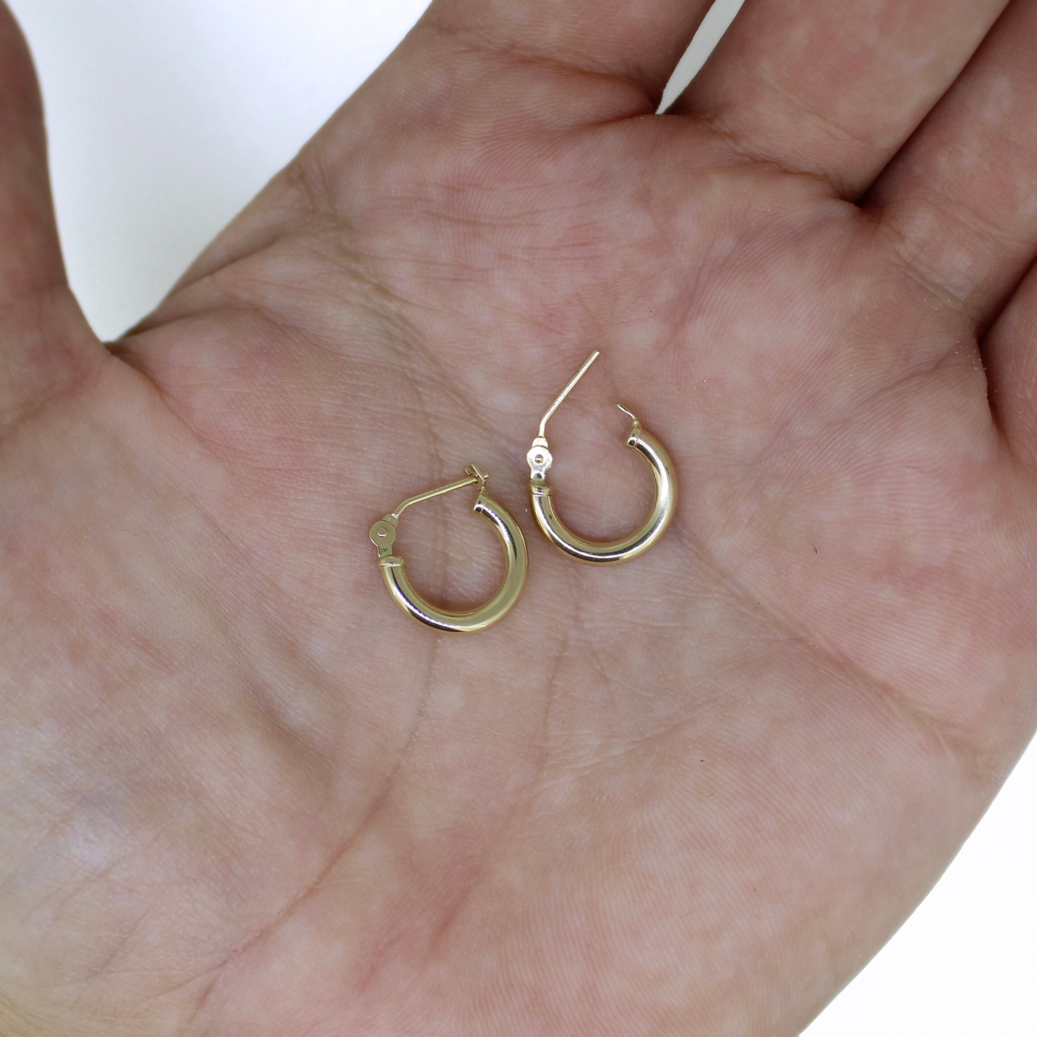 Brianne & Co. 14k gold 12mm hoops on palm of hand