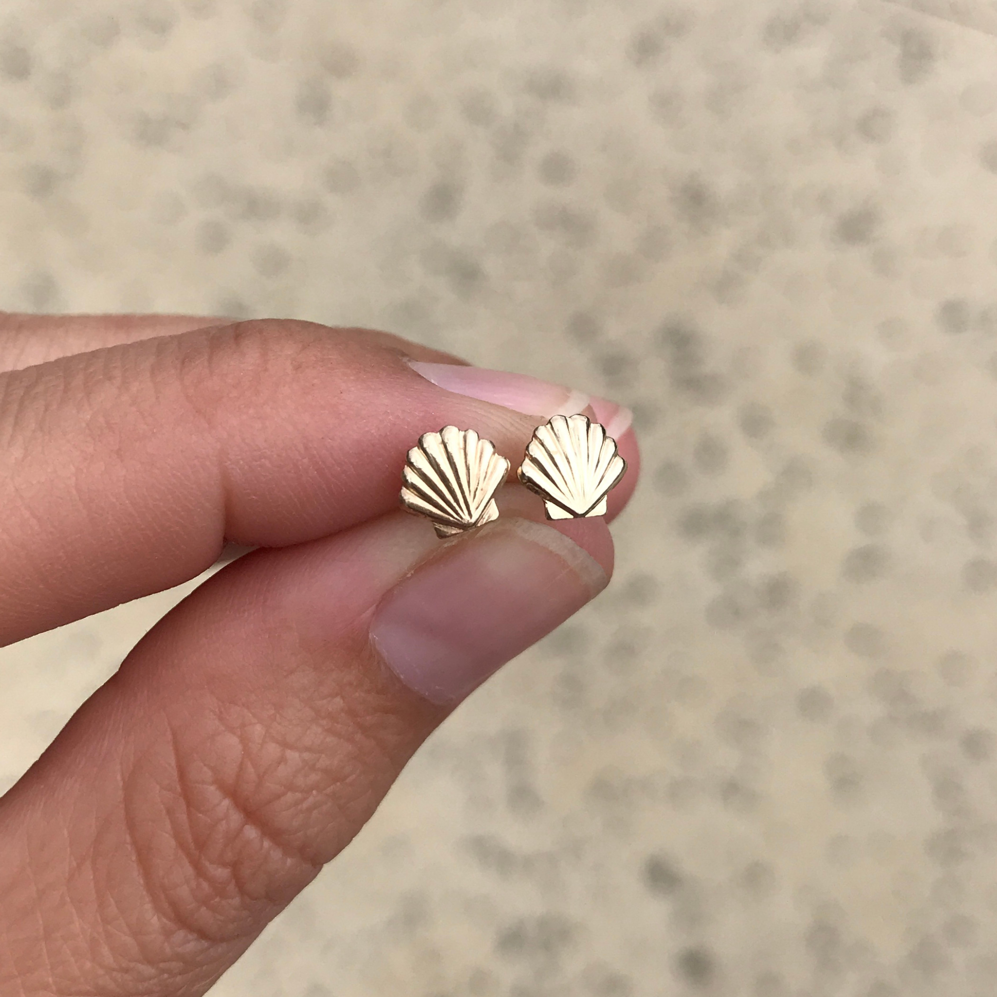 Brianne & Co. tiny gold fill shell stud earrings on hand for size reference