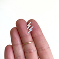 Brianne & Co. sterling silver small lightning bolt stud earrings in hand for size reference