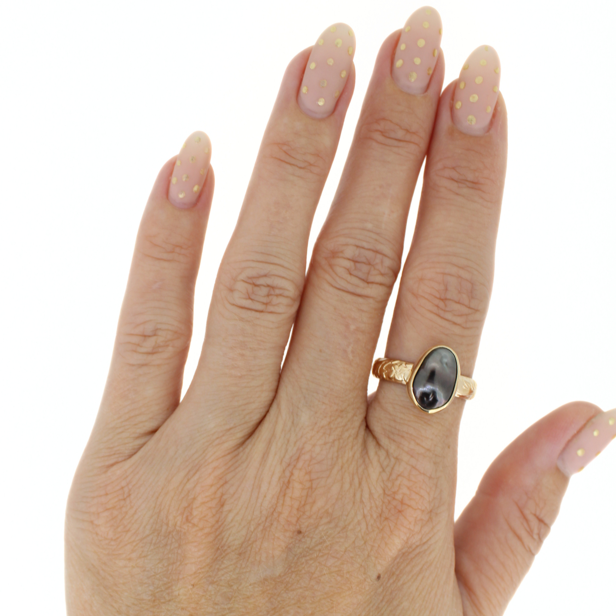Gold ring with oval dark keshi pearl, shown on hand