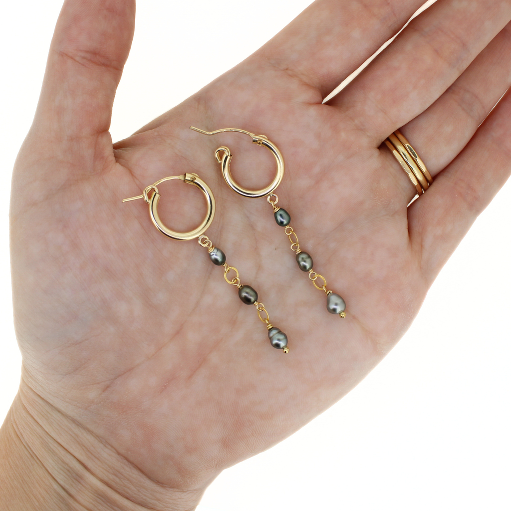 Brianne & Co. gold fill 15mm hoop earrings with little Tahitian keshi pearls on hand for size reference