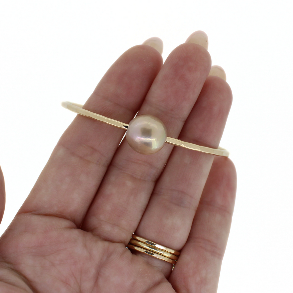 Brianne & Co. gold fill Edison pearl bangle on hand for size reference