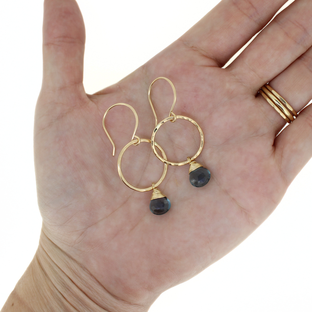 Brianne & Co. gold fill hoop earrings with blue quartz on hand for size reference