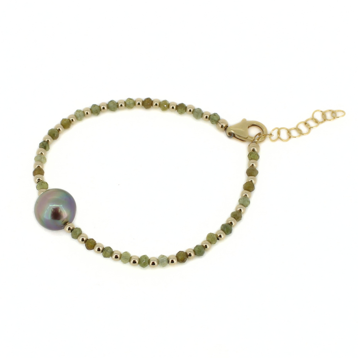 A delicate gold chain bracelet featuring faceted green beads, small gold beads, and a large round iridescent pearl bead, displayed on a clean white background.
