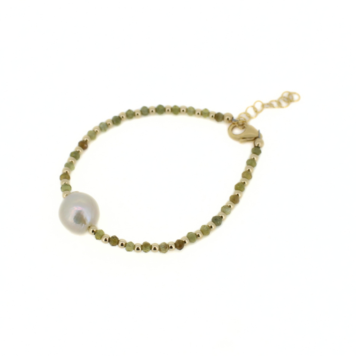A delicate gold beaded bracelet featuring a large, lustrous white baroque pearl and small faceted green beads, displayed on a clean white background.