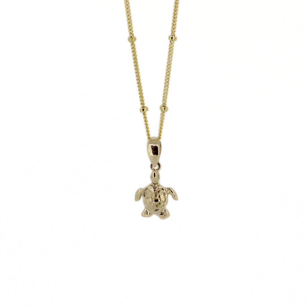 Brianne & Co. 14k gold tiny honu turtle pendant on a gold fill satellite chain