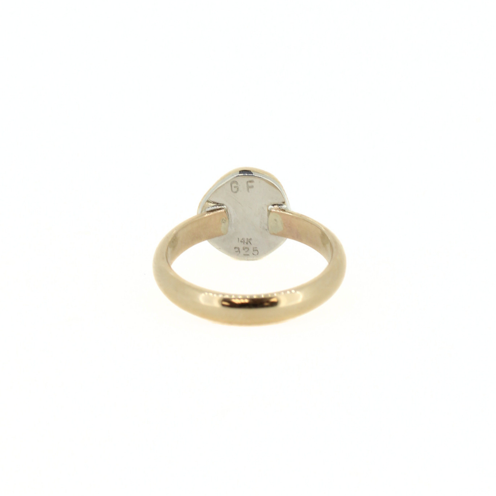 Gold-tone puka shell ring underside with hallmarks, including 925