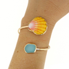 Brianne & Co. gold sunrise shell and sea glass bypass style cuff on wrist