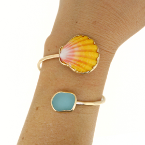 Brianne & Co. gold sunrise shell and sea glass bypass style cuff on wrist